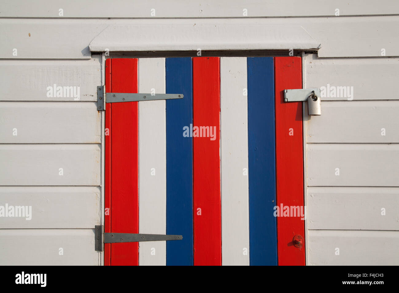 Dipinto di rosso bianco e blu di chiusura dell'otturatore in legno su un dipinto di bianco beach hut a Southwold Suffolk in Inghilterra Foto Stock