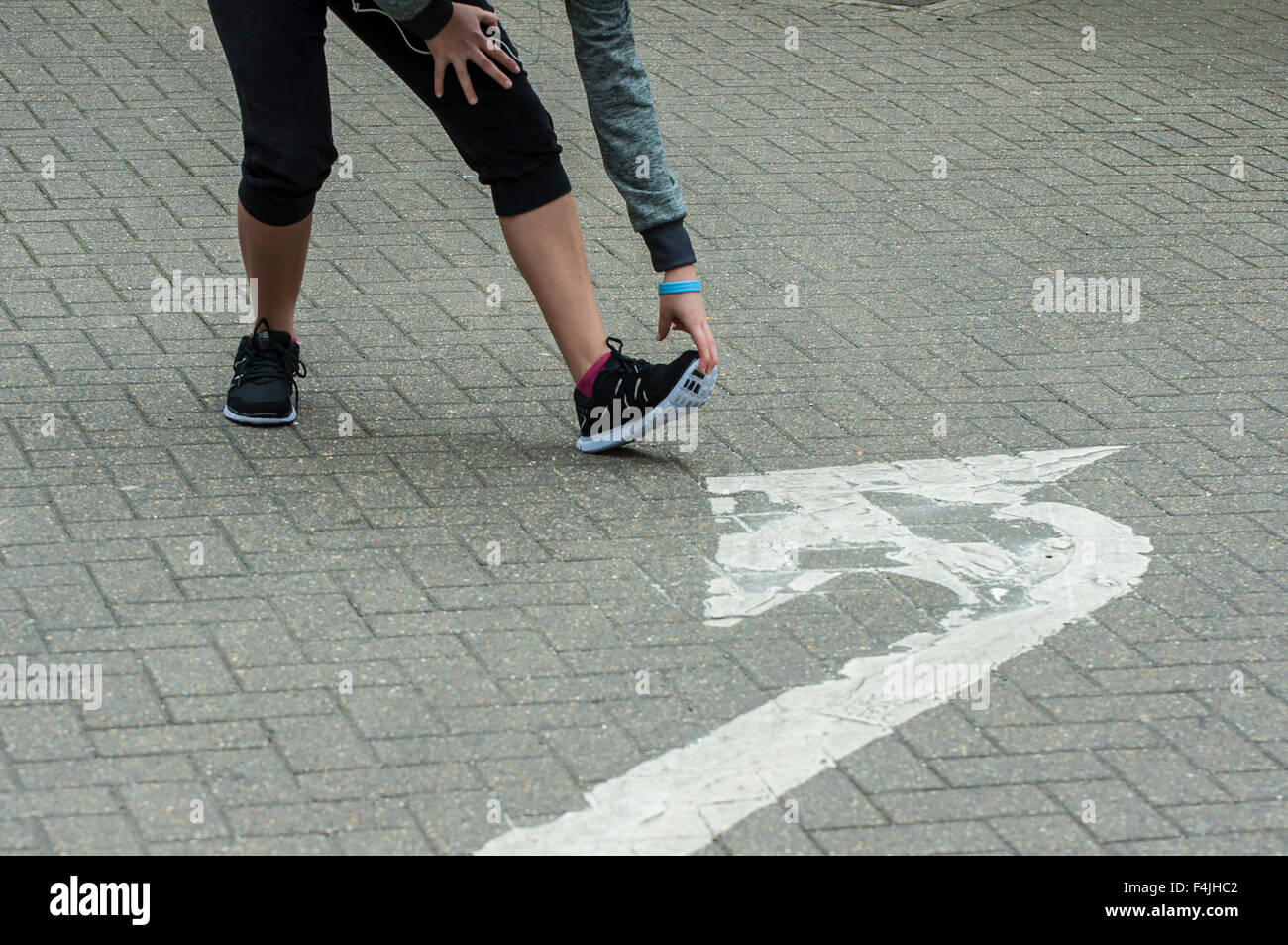 Una giovane donna fare sport e stretching outdoor con abbigliamento sportivo. Foto Stock