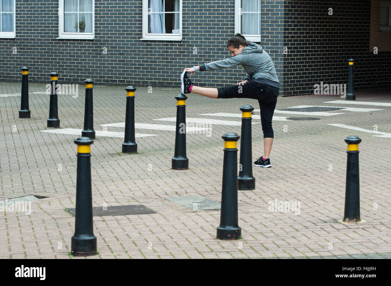 Una giovane donna fare sport e stretching outdoor con abbigliamento sportivo. Foto Stock