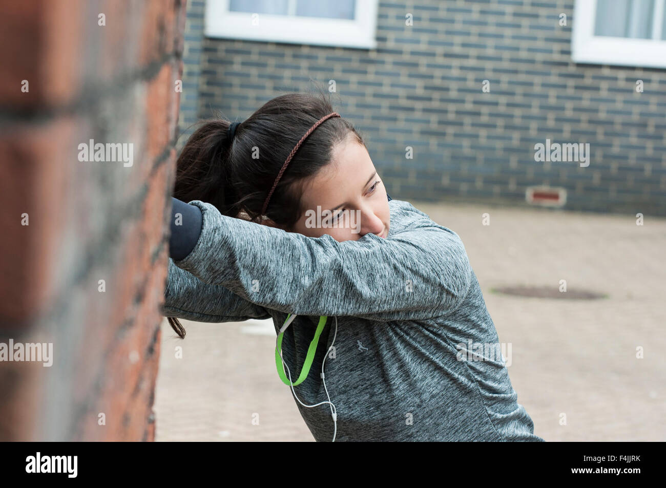 Una giovane donna fare sport e stretching outdoor con abbigliamento sportivo. Foto Stock