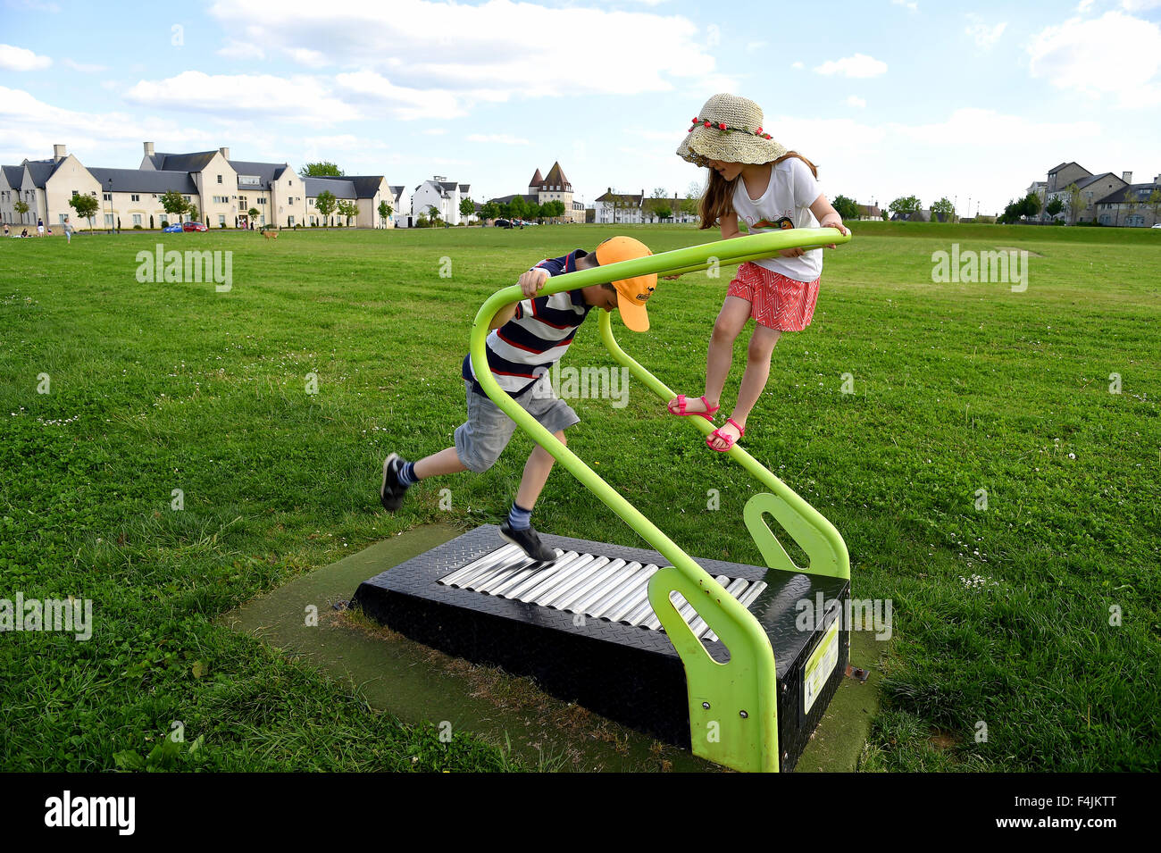 I bambini giocano nel grande campo al villaggio Poundbury, Dorset, Gran Bretagna, Regno Unito Foto Stock