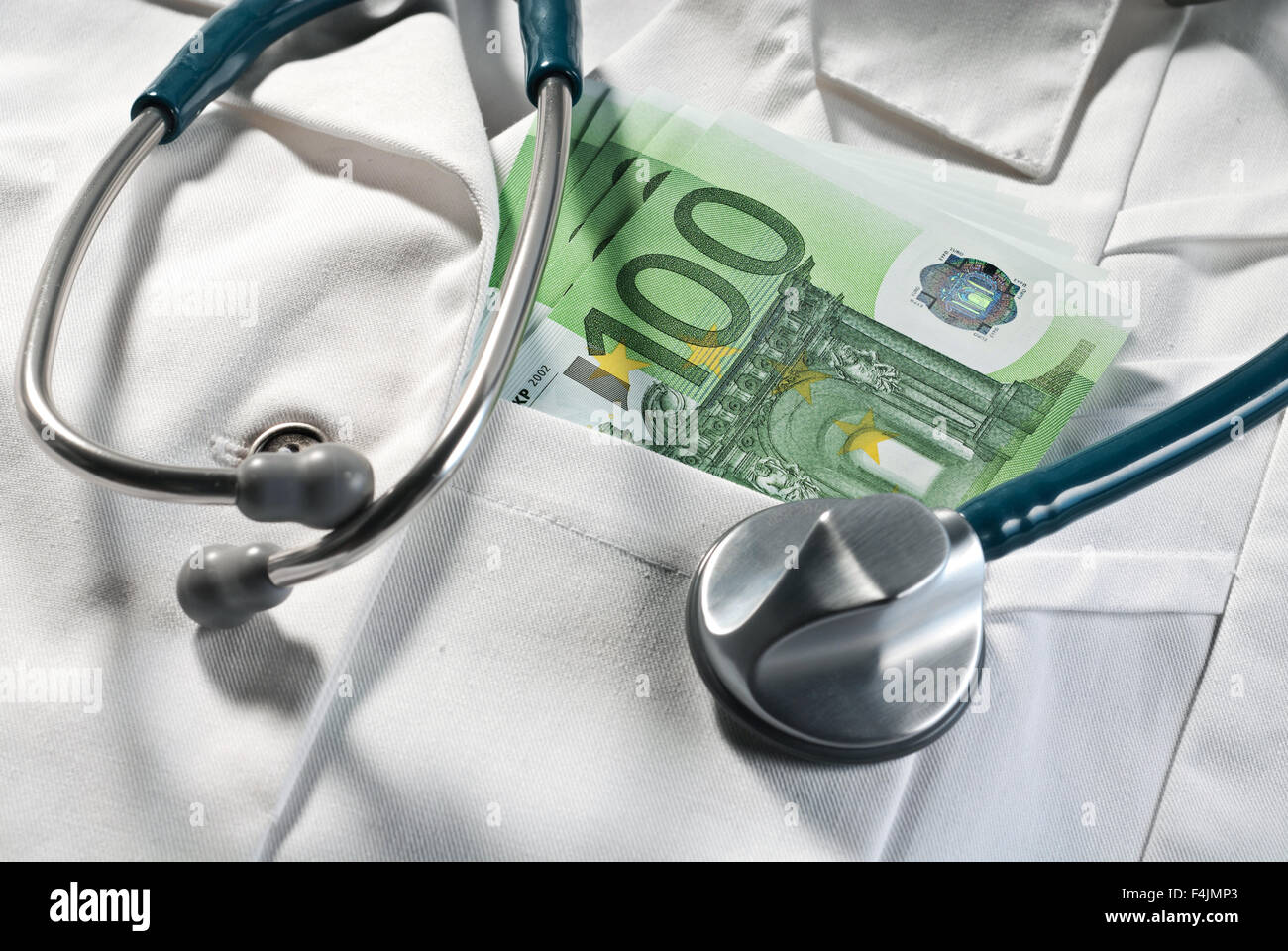 Lo stetoscopio e bollette di denaro su un medico del mantello Foto Stock