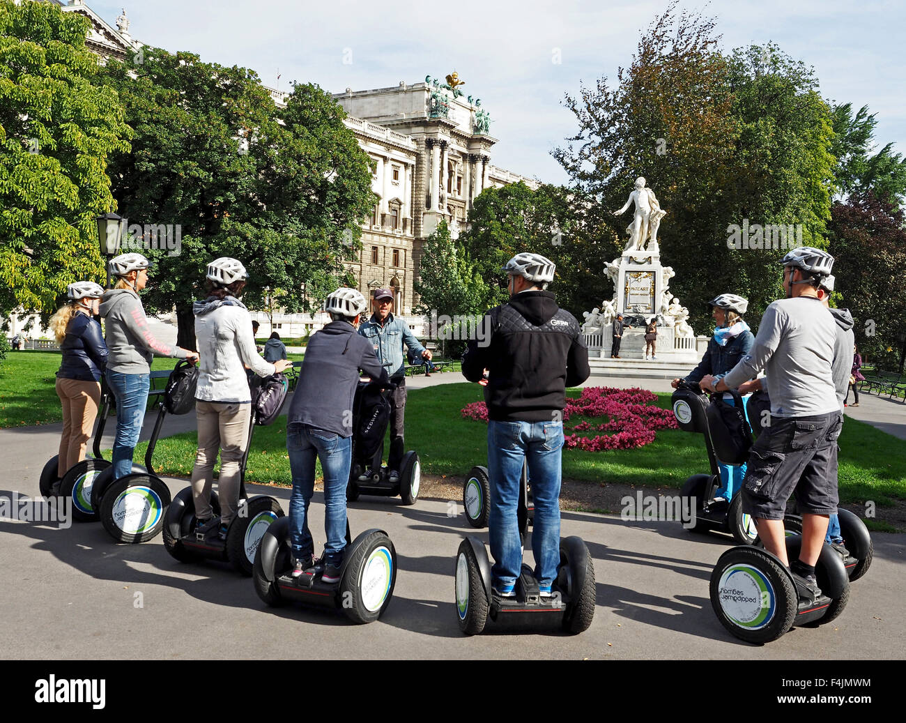Segway tour presso il monumento di Mozart nel Burggarten o giardini del Palazzo Imperiale nel centro di Vienna, Austria. Foto Stock