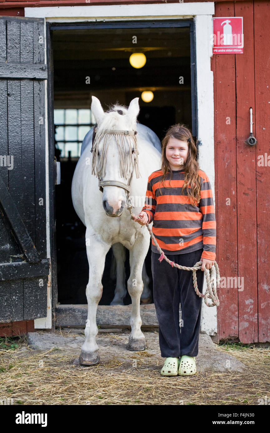 La Svezia, Uppsala, ritratto di una ragazza (10-11) con cavallo fuori stabile Foto Stock
