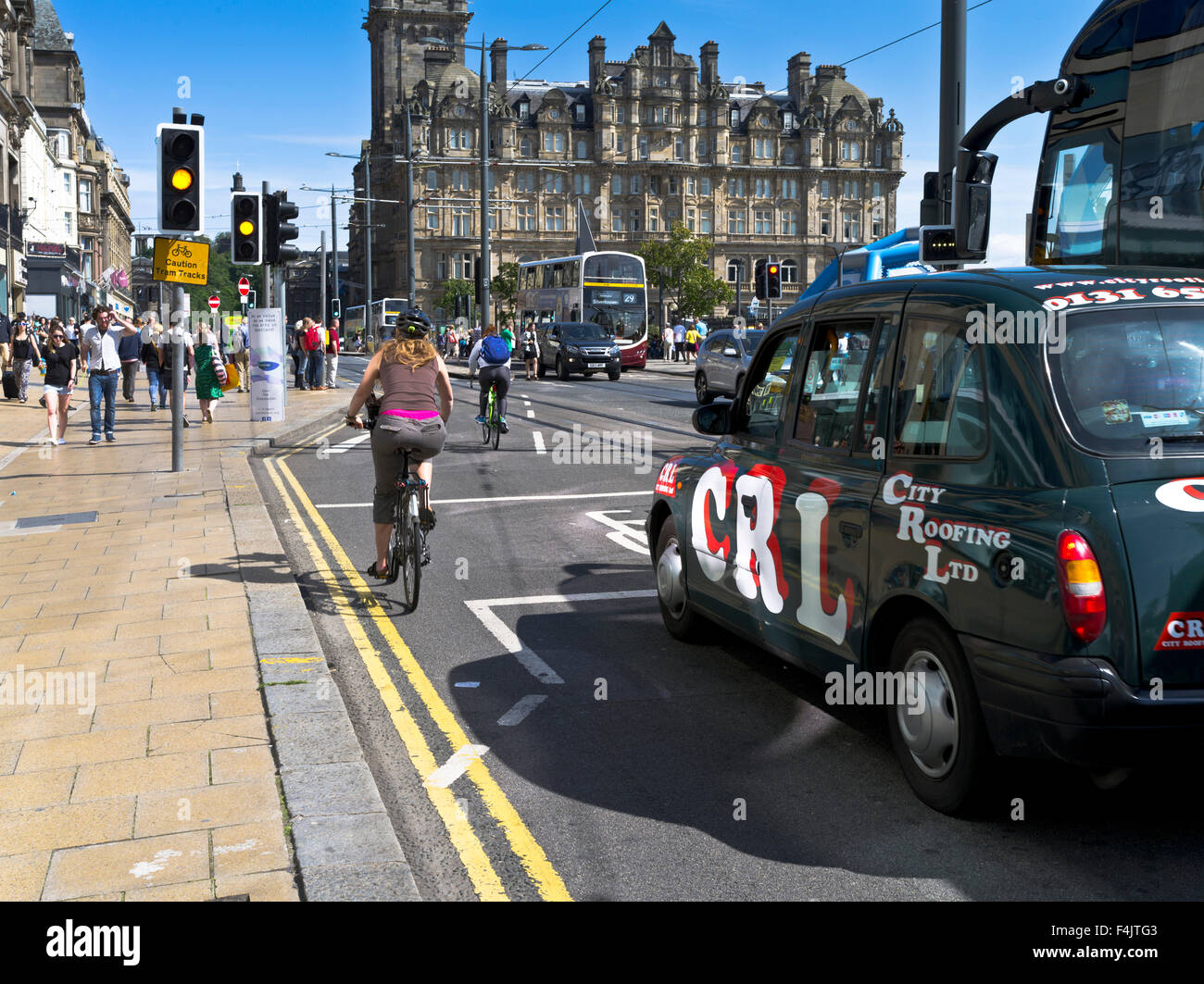 dh Scottish semafori PRINCES STREET EDINBURGH SCOTLAND ciclista in bicicletta corsia taxi donna ciclismo uk città scozia ciclisti occupati Foto Stock