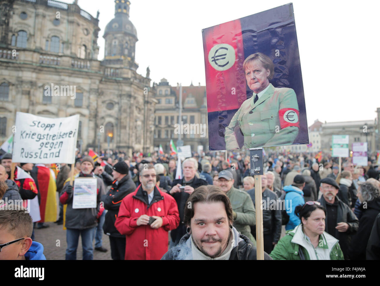 Dresden, Germania. Xix oct, 2015. Un dimostrante il segno mostra il cancelliere tedesco Merkel in uniforme che indossa una fascia da braccio Euro a Dresda, Germania, 19 ottobre 2015. Un anno fa, Pegida (patriottici europei contro la Islamification del West), hanno dimostrato per le strade per la prima volta. L'anti-gruppo di immigranti è la pianificazione di una dimostrazione sul suo anniversario. Foto: MICHAEL KAPPELER/DPA/Alamy Live News Foto Stock