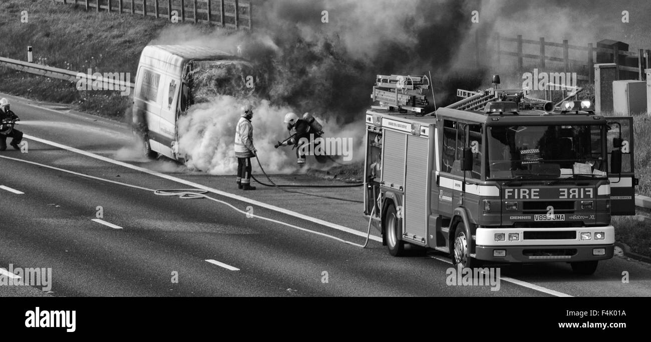 I vigili del fuoco di mettere fuori un furgone fire in autostrada Foto Stock