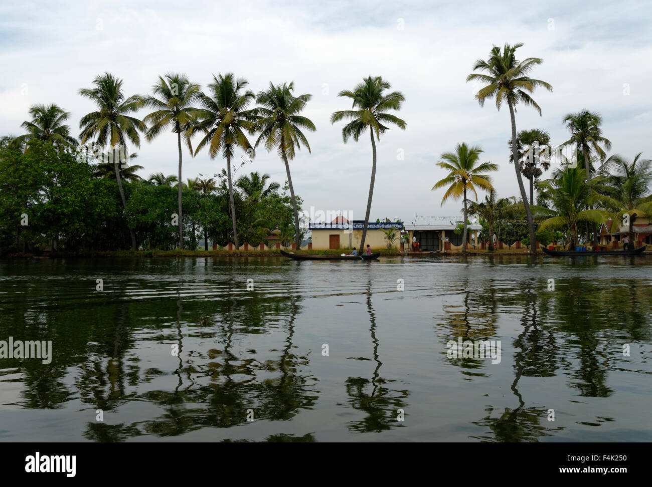 Palme e un ristorante lungo un fiume Foto Stock