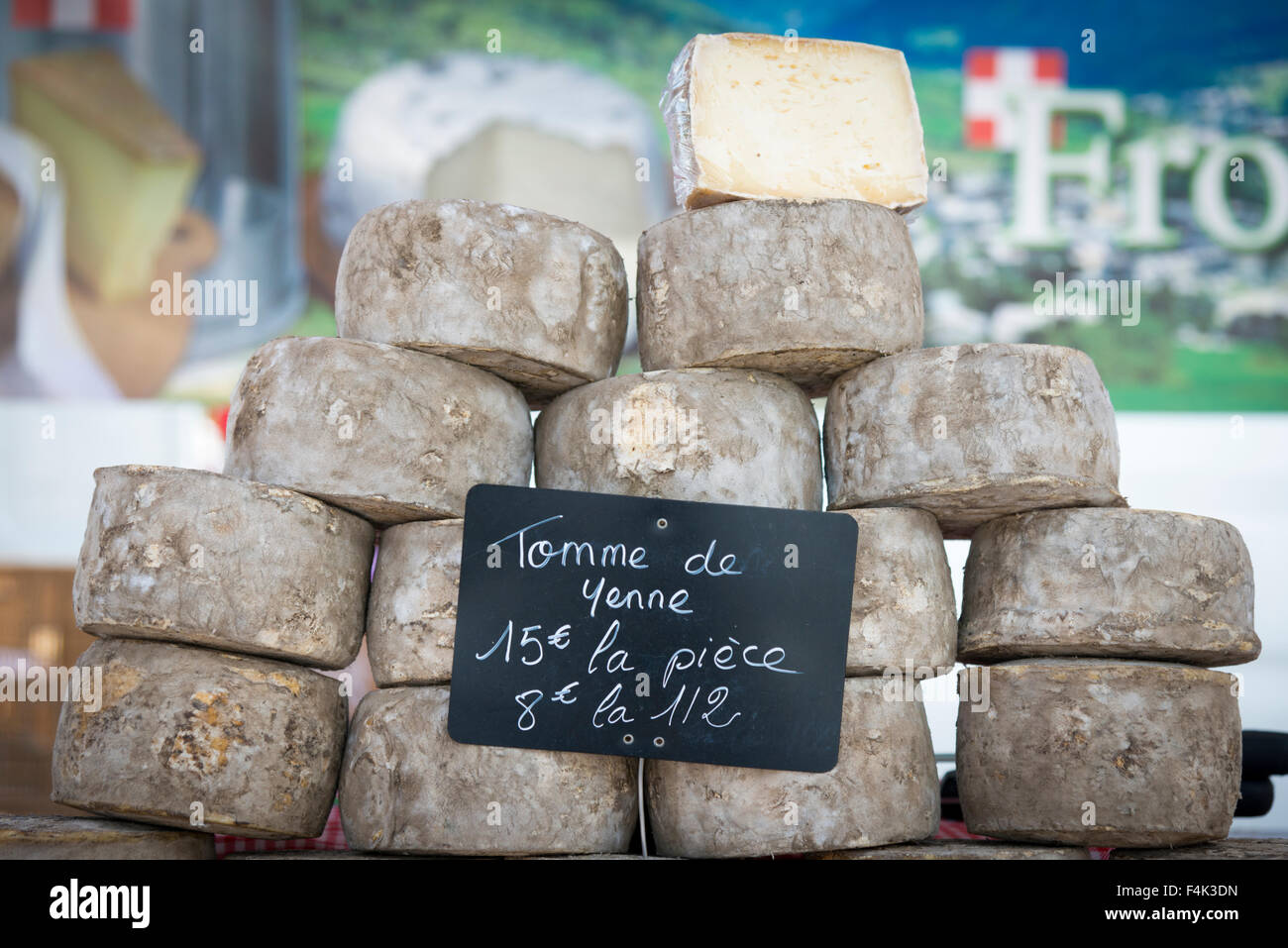 Un mucchio di Tomme de Yenne formaggio su un mercato in stallo in Francia Foto Stock