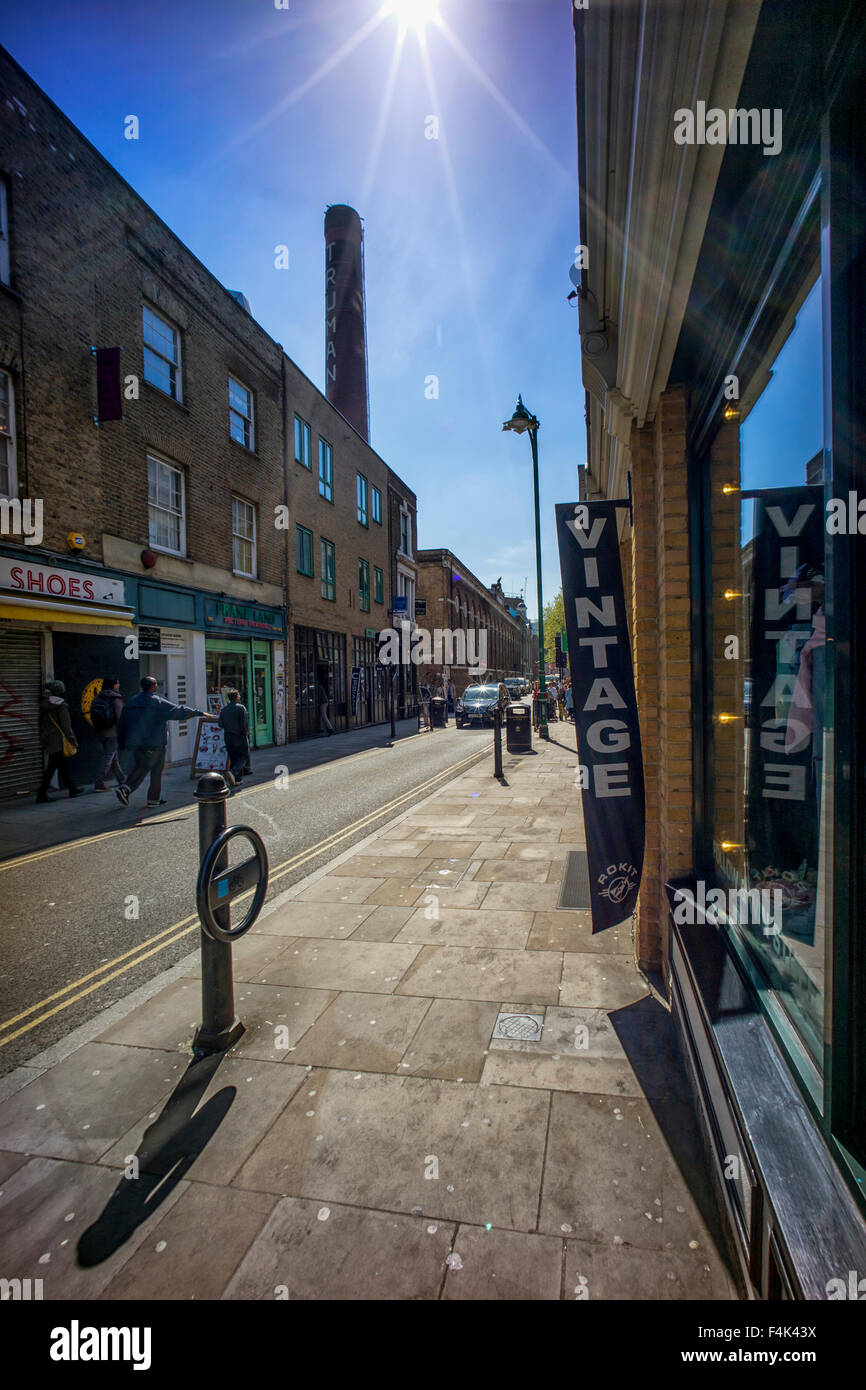 Brick Lane Spitalfields guardando verso il camino di spicco della vecchia Truman Brewery Foto Stock