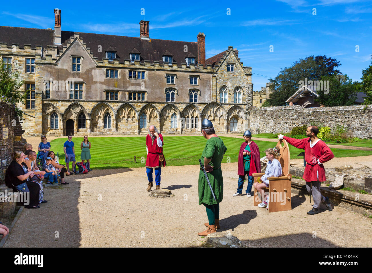Visitatori participatiing nella rievocazione storica di fronte all abate della grande hall (ora una scuola) all Abbazia di Battle, e Sussex, Regno Unito Foto Stock