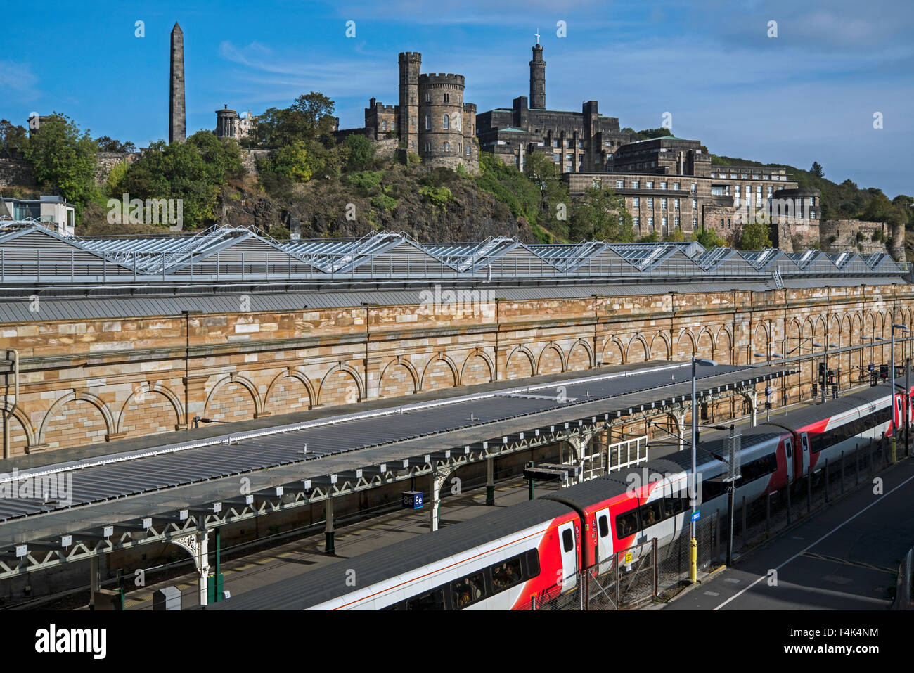 Un treno vergine permanente al Edinburgh Waverley Station con Calton Hill in background. Foto Stock