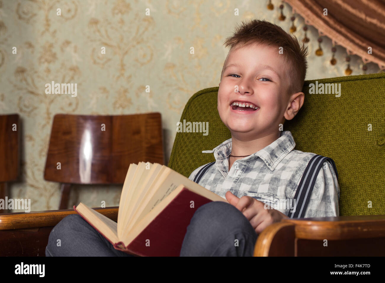Bambino Leggere il libro, Bambini Educazione, ben vestito Schoolboy su sfondo grigio Foto Stock