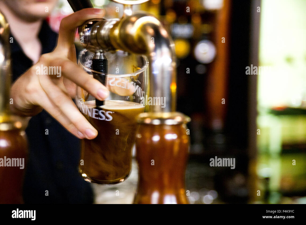 Il barista di colare una pinta di birra Guinness Foto Stock