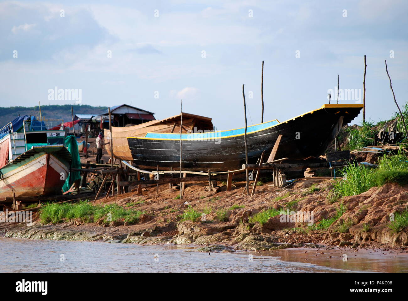 Piccola barca da pesca al di fuori dell'acqua a villaggi galleggianti sul fiume Tonle Sap, Cambogia Foto Stock