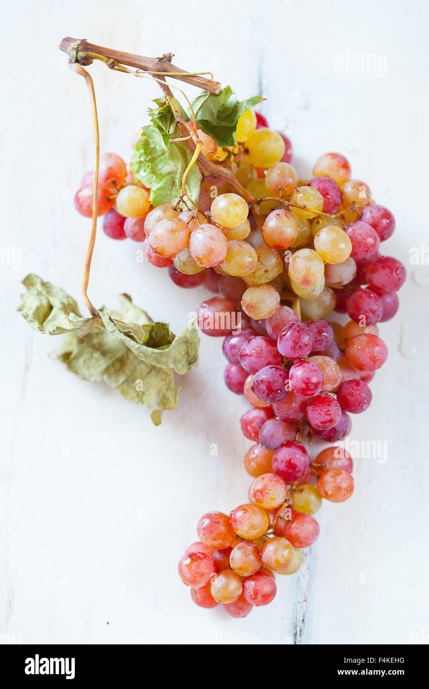 Uva bianca su sfondo di legno Foto Stock