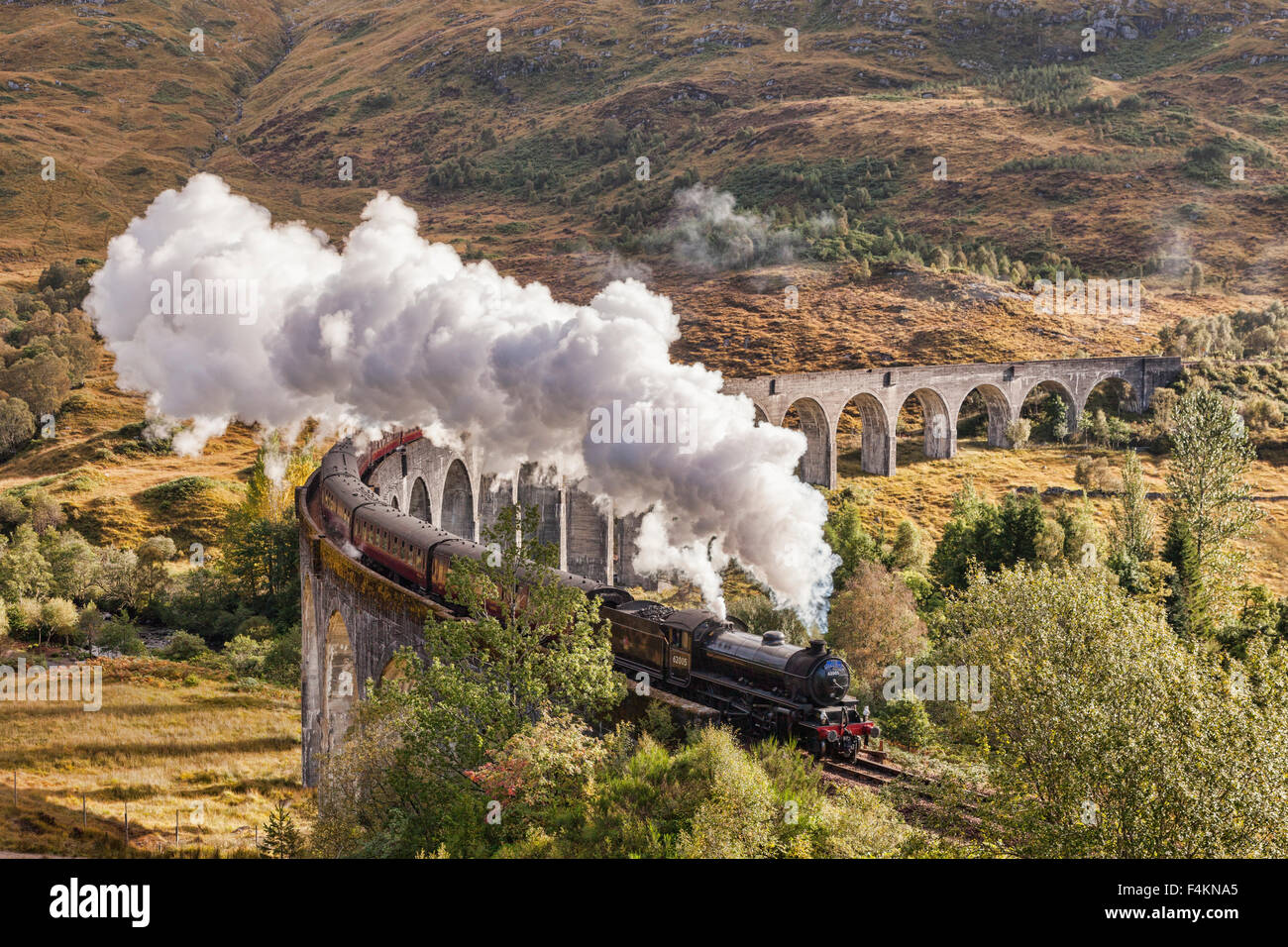 Il Giacobita treno a vapore che insuffla vapore dallo scarico come si attraversa il viadotto Glenfinnan, Highland, Scotland, Regno Unito. Foto Stock