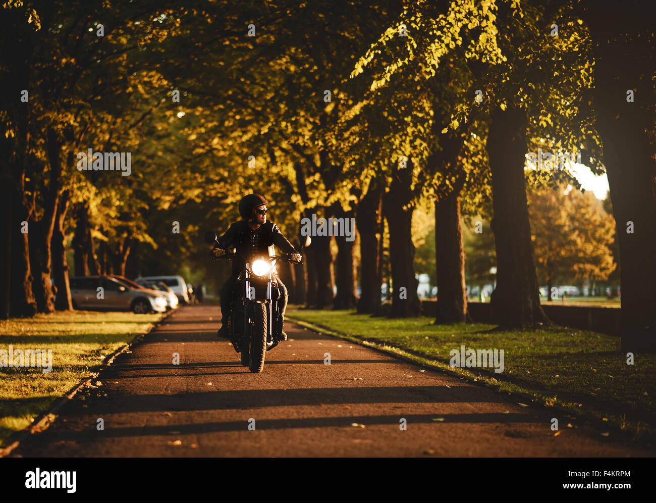 Uomo a cavallo di un cafè-racer motociclo Foto Stock