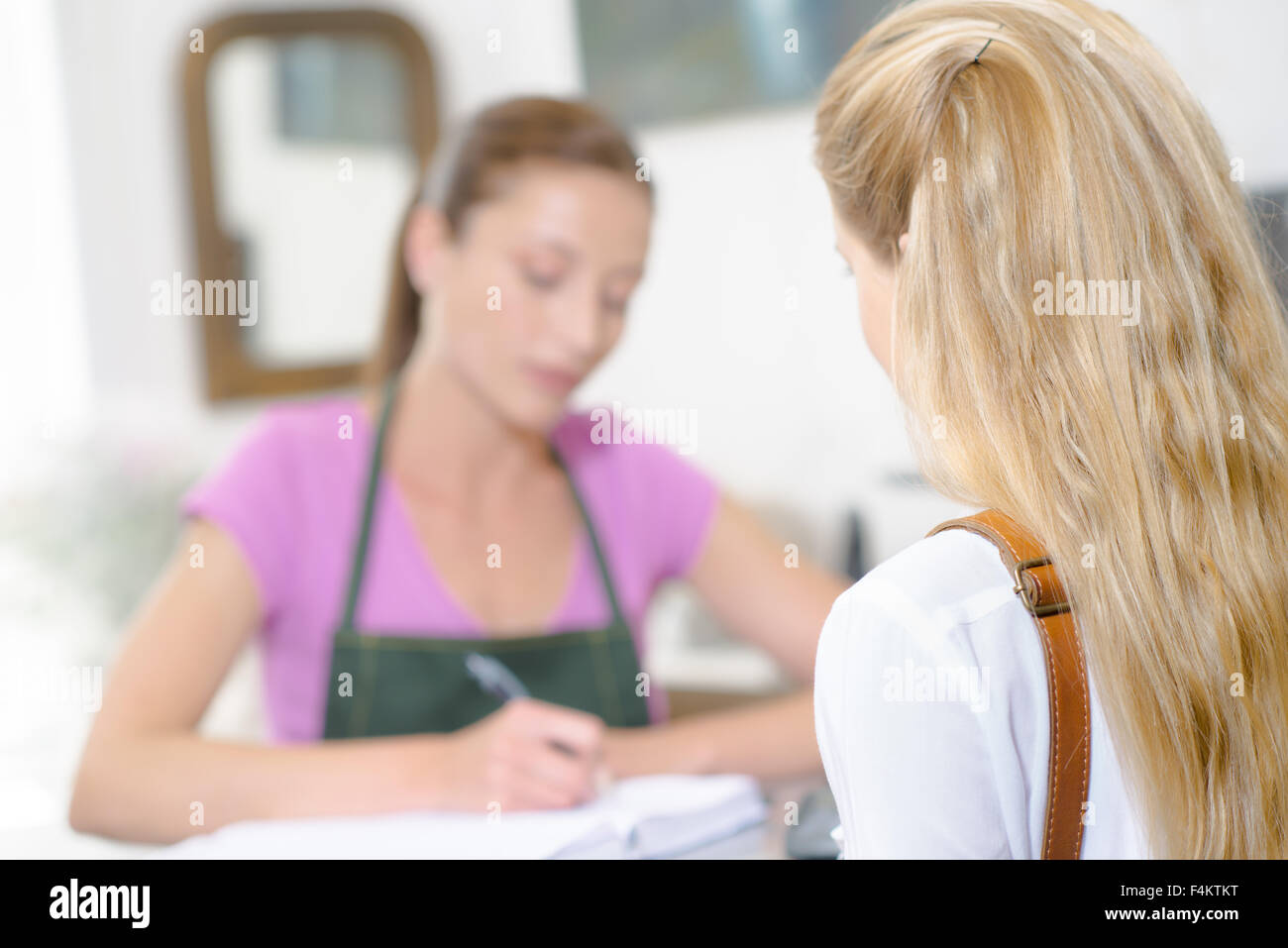 Signora tenendo la prenotazione da parte del cliente Foto Stock