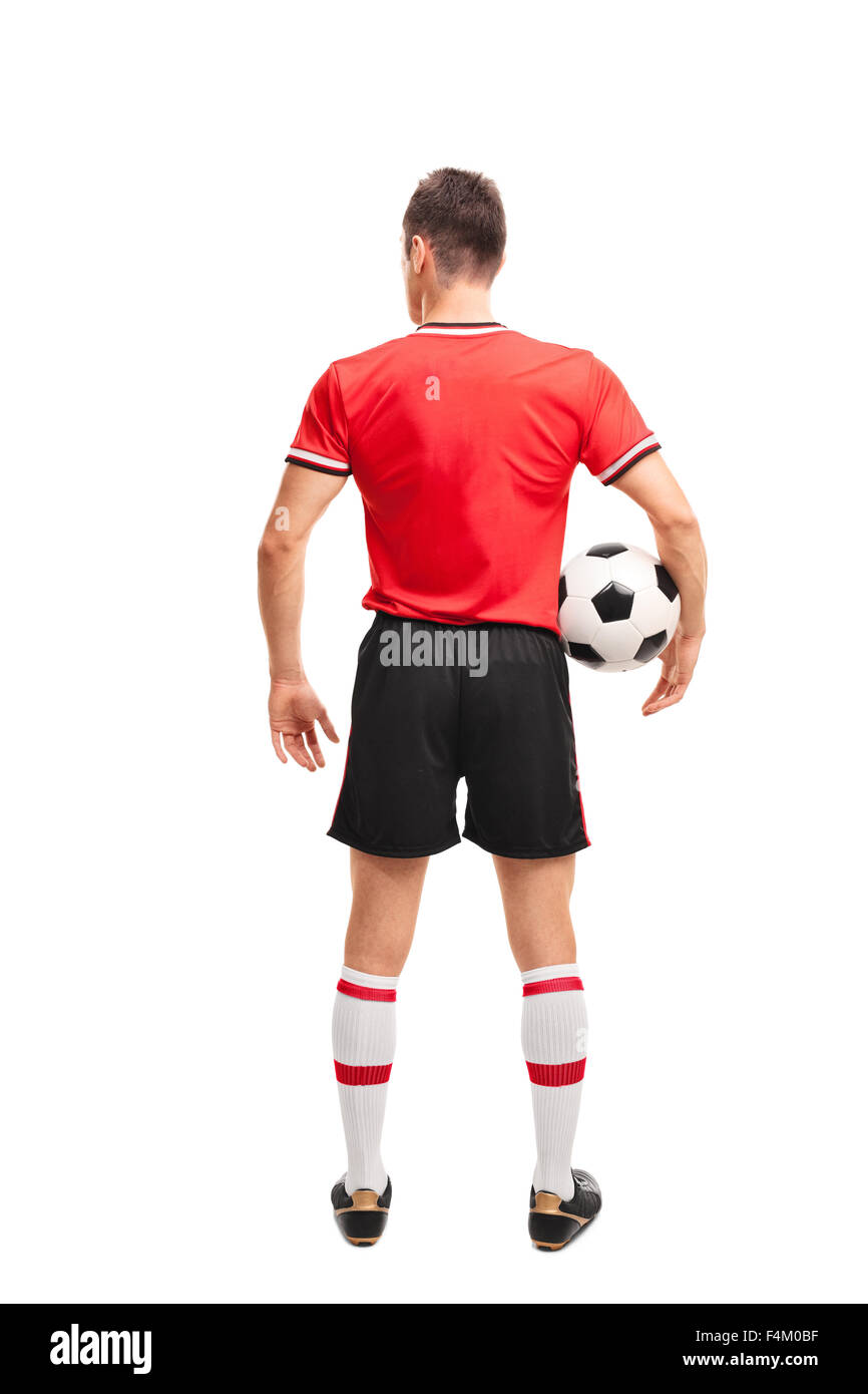 Lunghezza piena vista posteriore colpo di un giovane calciatore in maglia rossa tenendo una palla isolati su sfondo bianco Foto Stock Lunghezza piena vista posteriore colpo di un giovane calciatore in maglia rossa tenendo una palla isolati su sfondo bianco Foto Stock