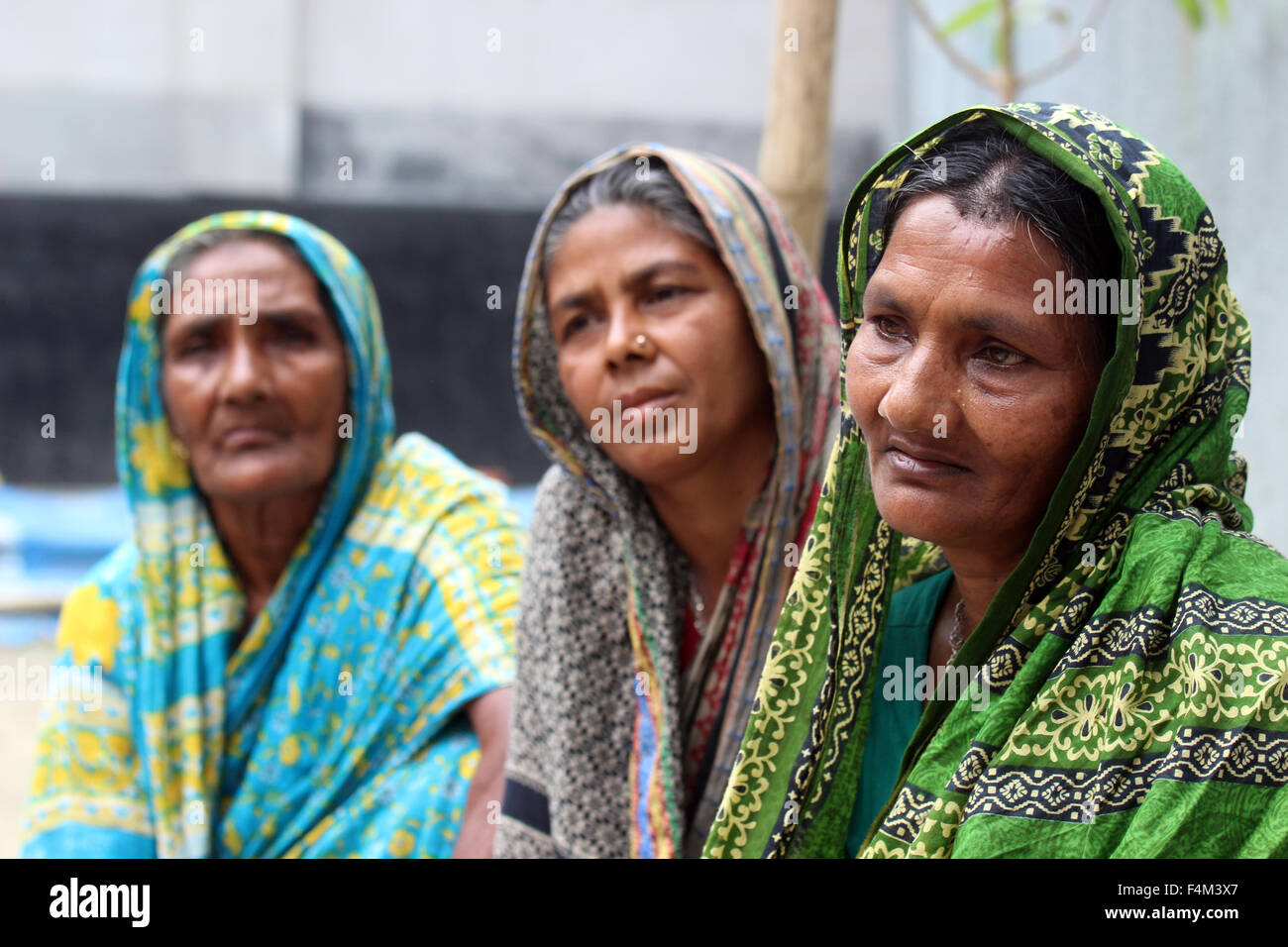 Anwara iniziata, Heena e Tulsi (l-r) siedono nel cortile del iniziata la capanna nel villaggio di Outpara in Bangladesh, 8 aprile 2015. Fino a pochi anni fa, le tre donne apparteneva al più povero dei poveri in Bangladesh e raramente avuto due pasti al giorno. A causa di un programma avviato dal Bangladesh a base di 'ONG Brac', le tre donne ora animali e hanno pasti regolari. Brac si sta concentrando in particolare parti povere della popolazione raggiungendo circa 1, 6 milioni di famiglie e di contribuire fino al 95 percento delle persone di muoversi al di fuori della povertà. Foto: Doreen Fiedler/dpa Foto Stock