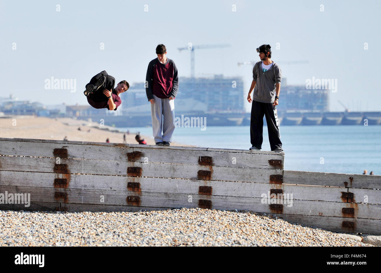 Brighton, Regno Unito. 20 ottobre, 2015. Tre giovani uomini fanno la maggior parte del tempo bello come essi affinare le proprie abilità acrobatiche su un mare difesa groyne sulla spiaggia di Brighton oggi Credito: Simon Dack/Alamy Live News Foto Stock