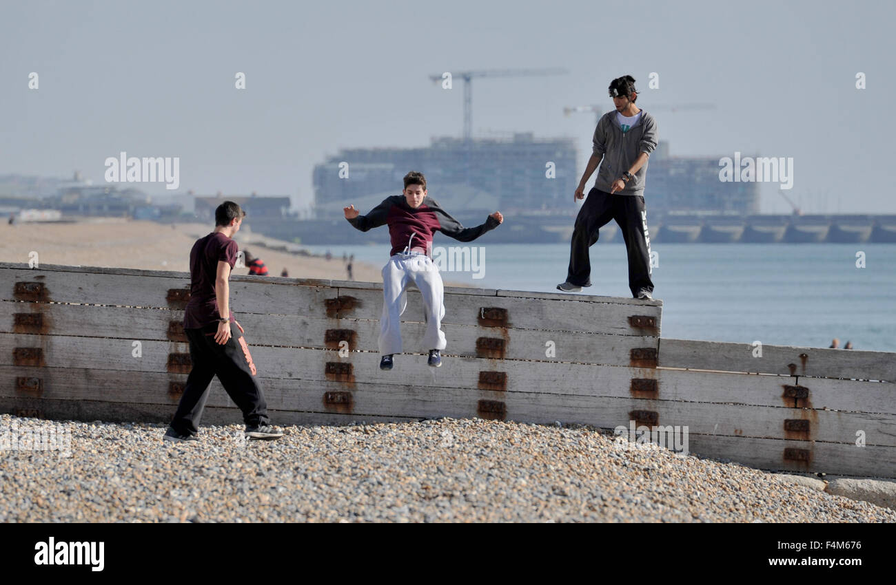 Brighton, Regno Unito. 20 ottobre, 2015. Tre giovani uomini fanno la maggior parte del tempo bello come essi affinare le proprie abilità acrobatiche su un mare difesa groyne sulla spiaggia di Brighton oggi Credito: Simon Dack/Alamy Live News Foto Stock