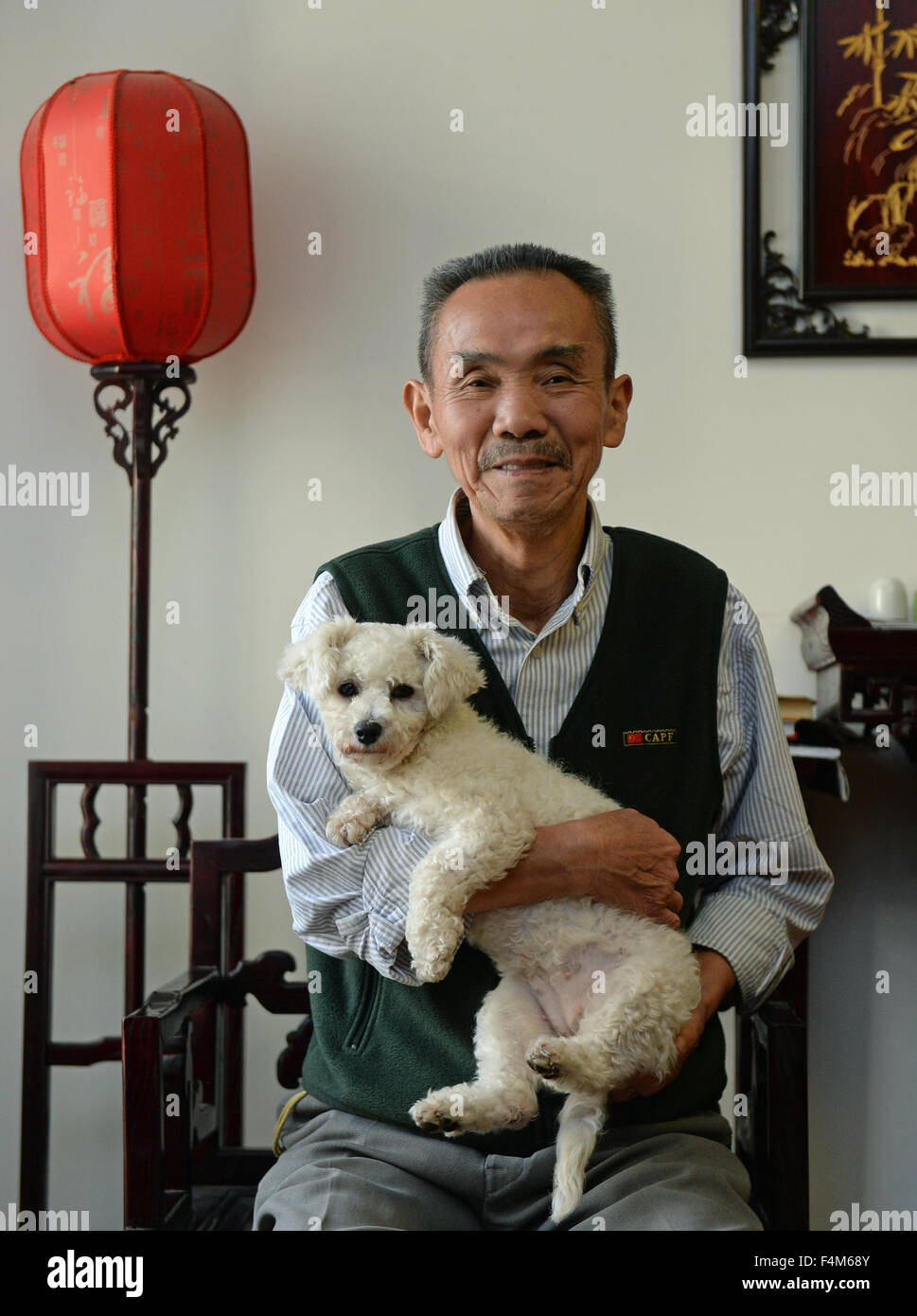 Pechino, Cina della provincia di Jiangxi. Xvi oct, 2015. Il 77-anno-vecchio Zhang Yu tiene il suo cane di nome Niuniu a casa di Nanchang, a est della capitale cinese della provincia di Jiangxi, 16 ottobre 2015. Entro la fine del 2014, il numero dei cinesi senior di persone al di sopra dei 60 anni di età era di 212 milioni di euro, circa il 15,5 per cento della popolazione totale del paese. Oggi più e più alti in Cina si preferiscono per sollevare gli animali domestici che sono state collaudate per rendere al contributo positivo a un senior citizen la vita. © Xiang Wan/Xinhua/Alamy Live News Foto Stock