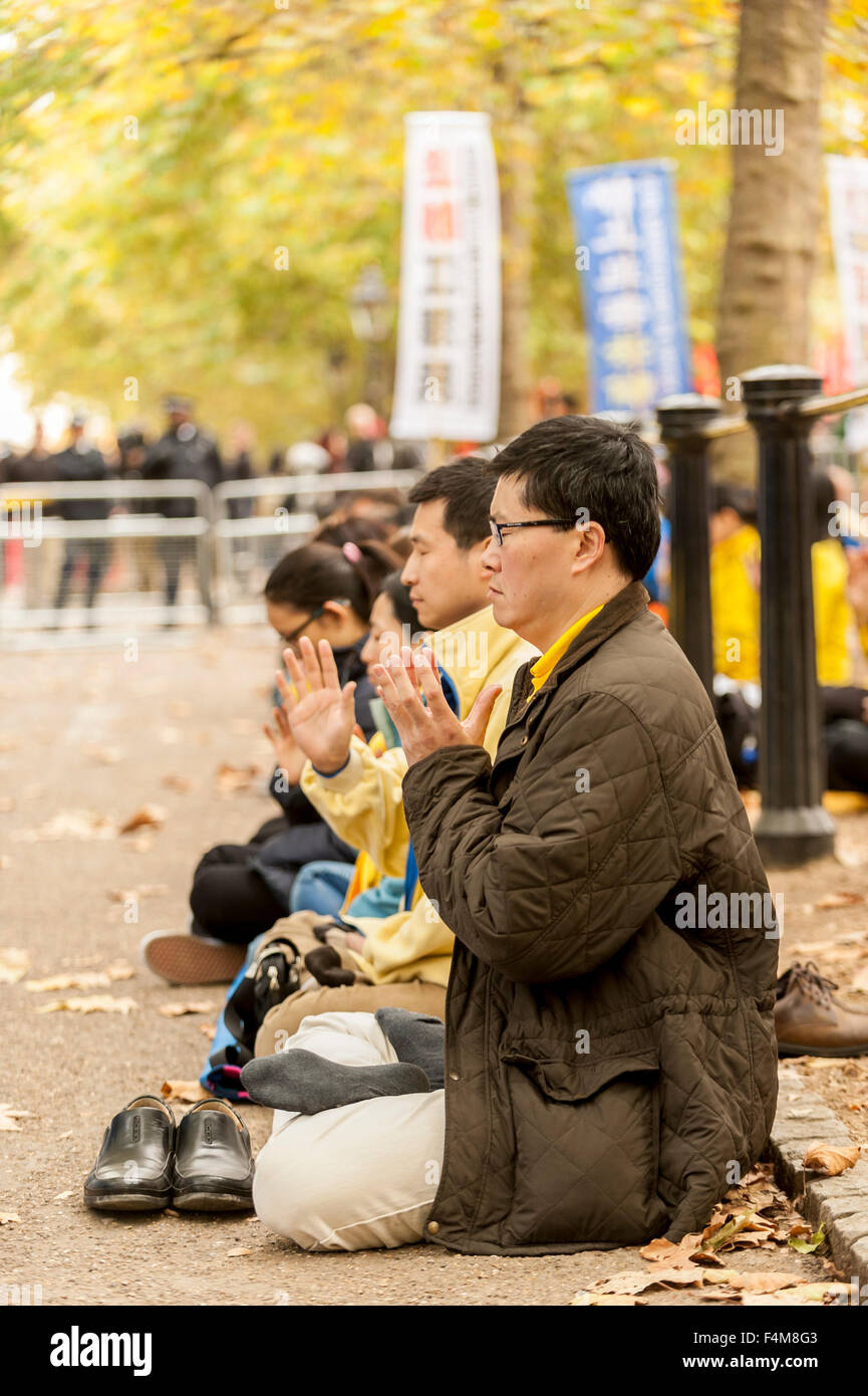 Londra, Regno Unito. Il 20 ottobre 2015. I membri della setta Falun Gong meditare in opposizione come la folla di attendere per vedere il presidente cinese Xi Jinping, viaggio verso il Mall in rotta verso Buckingham Palace, durante la sua visita di Stato nel Regno Unito. Credito: Stephen Chung / Alamy Live News Foto Stock