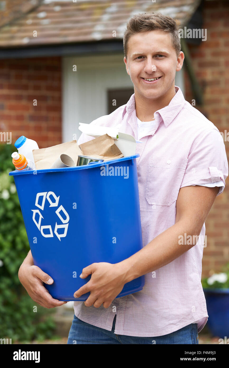 Ritratto di uomo che porta il contenitore di riciclaggio Foto Stock