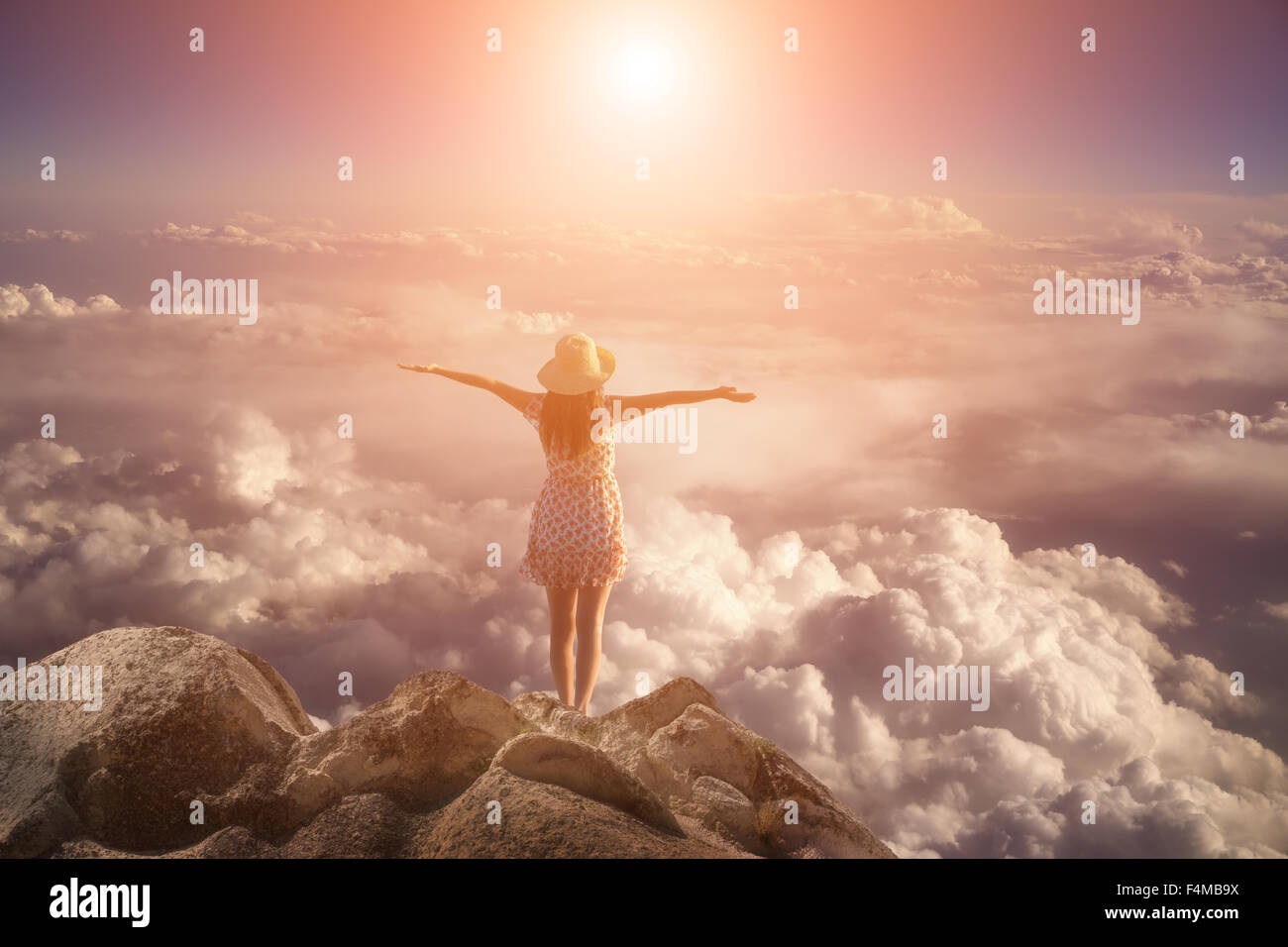 Libertà giovane donna di saltare sul picco di montagna rock Foto Stock