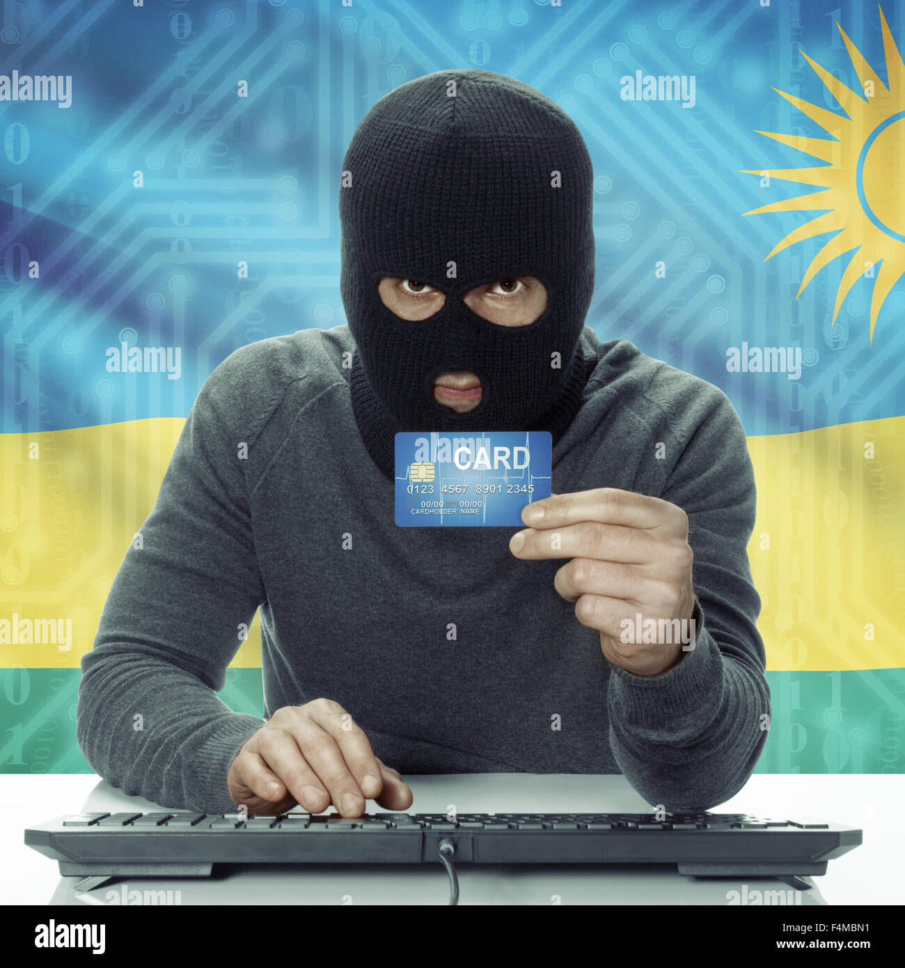 Di carnagione scura hacker con la carta di credito in mano e bandiera su sfondo - Rwanda Foto Stock