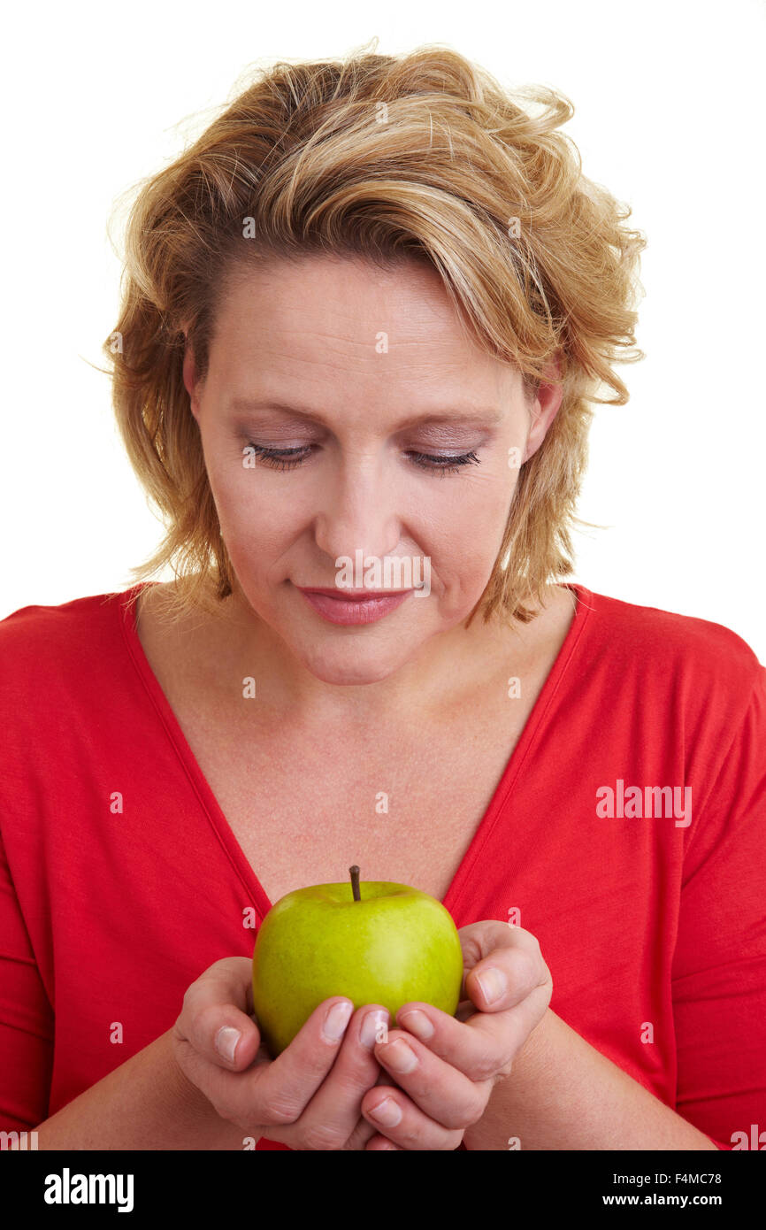 Soddisfatto la donna porta con cautela una mela verde Foto Stock