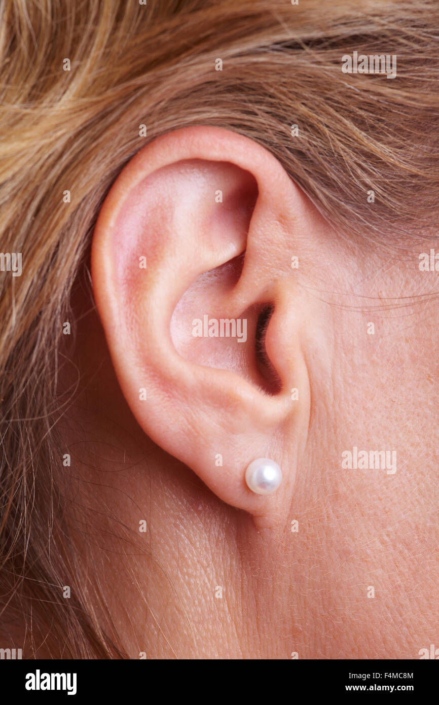 Primo piano della femmina con auricolari ear piercing Foto Stock