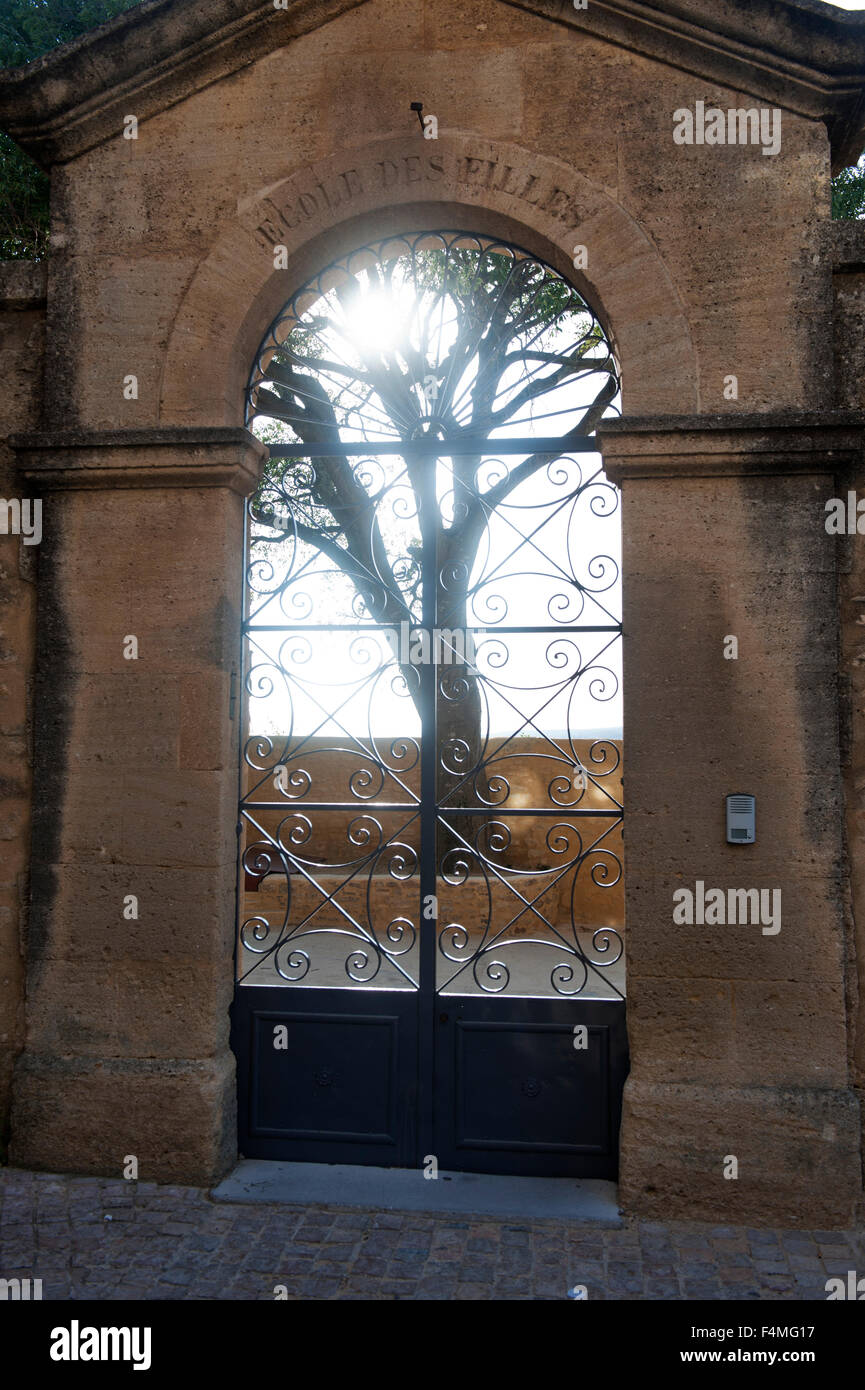 Antica pietra di ingresso e la porta di metallo con la penombra e albero in Provenza Francia Europa Foto Stock