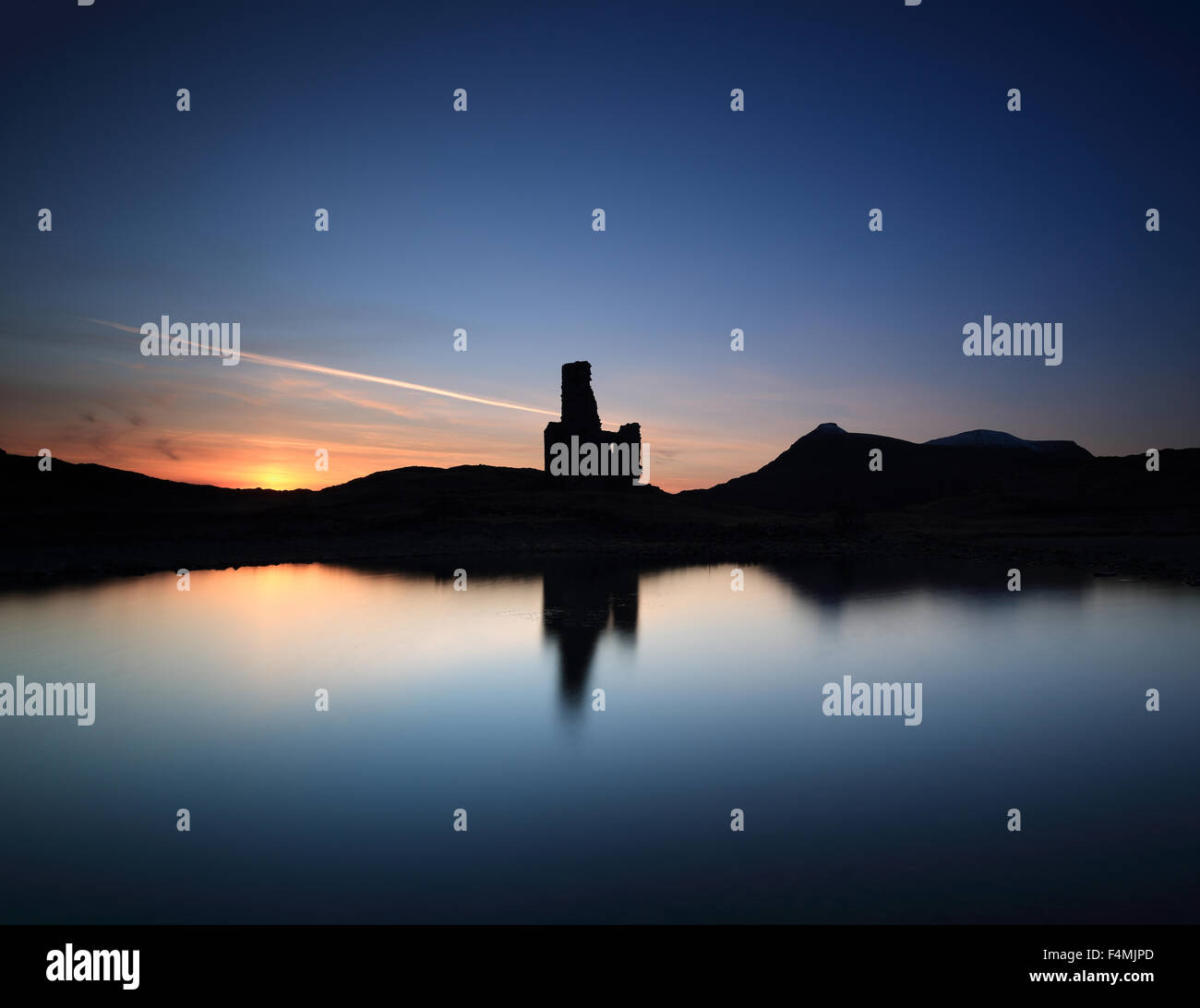 La splendida silhouette di Ardvreck Castle dalle sponde del Loch Assynt al tramonto Foto Stock