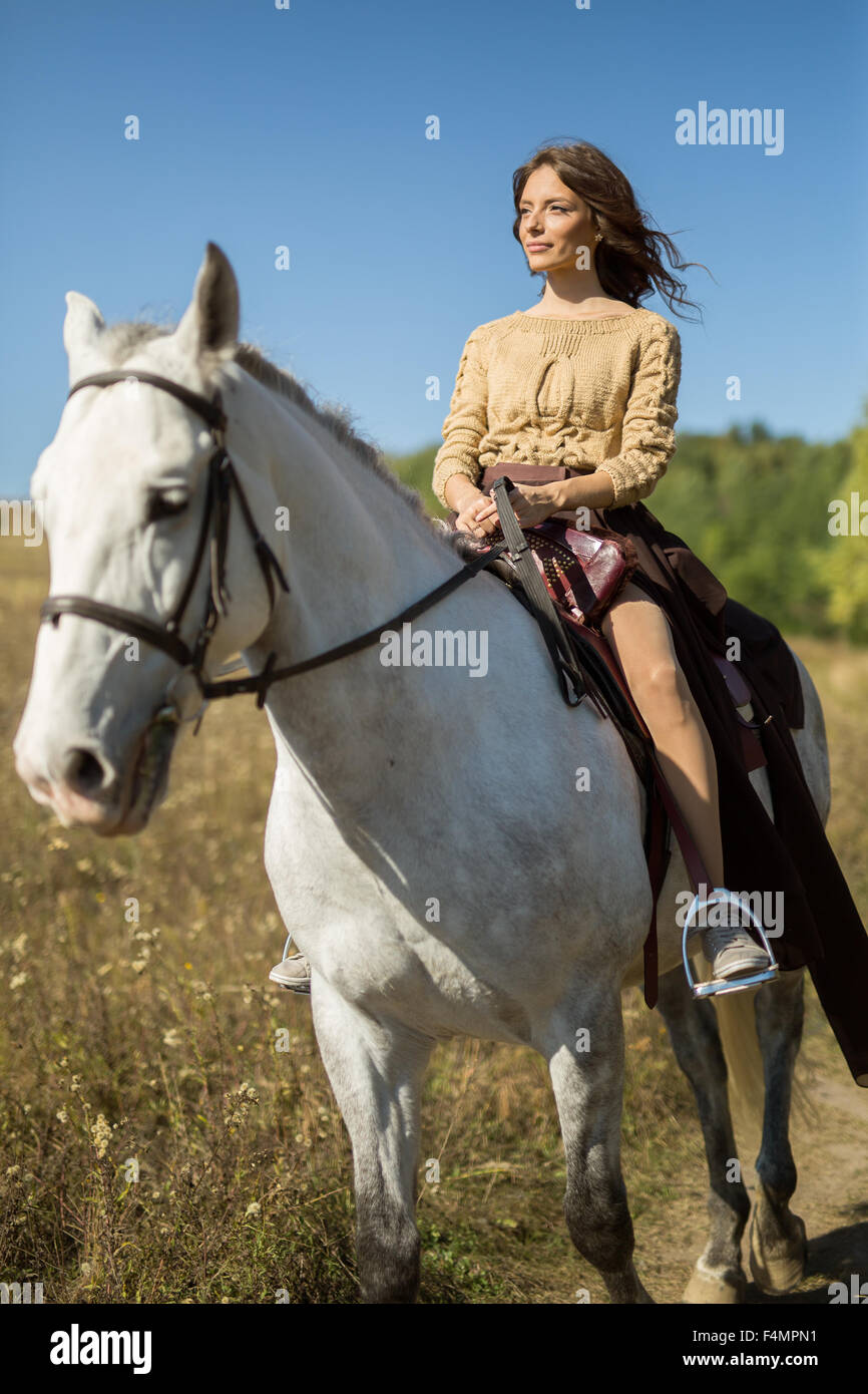 Bella ragazza in sella ad un cavallo bianco Foto Stock