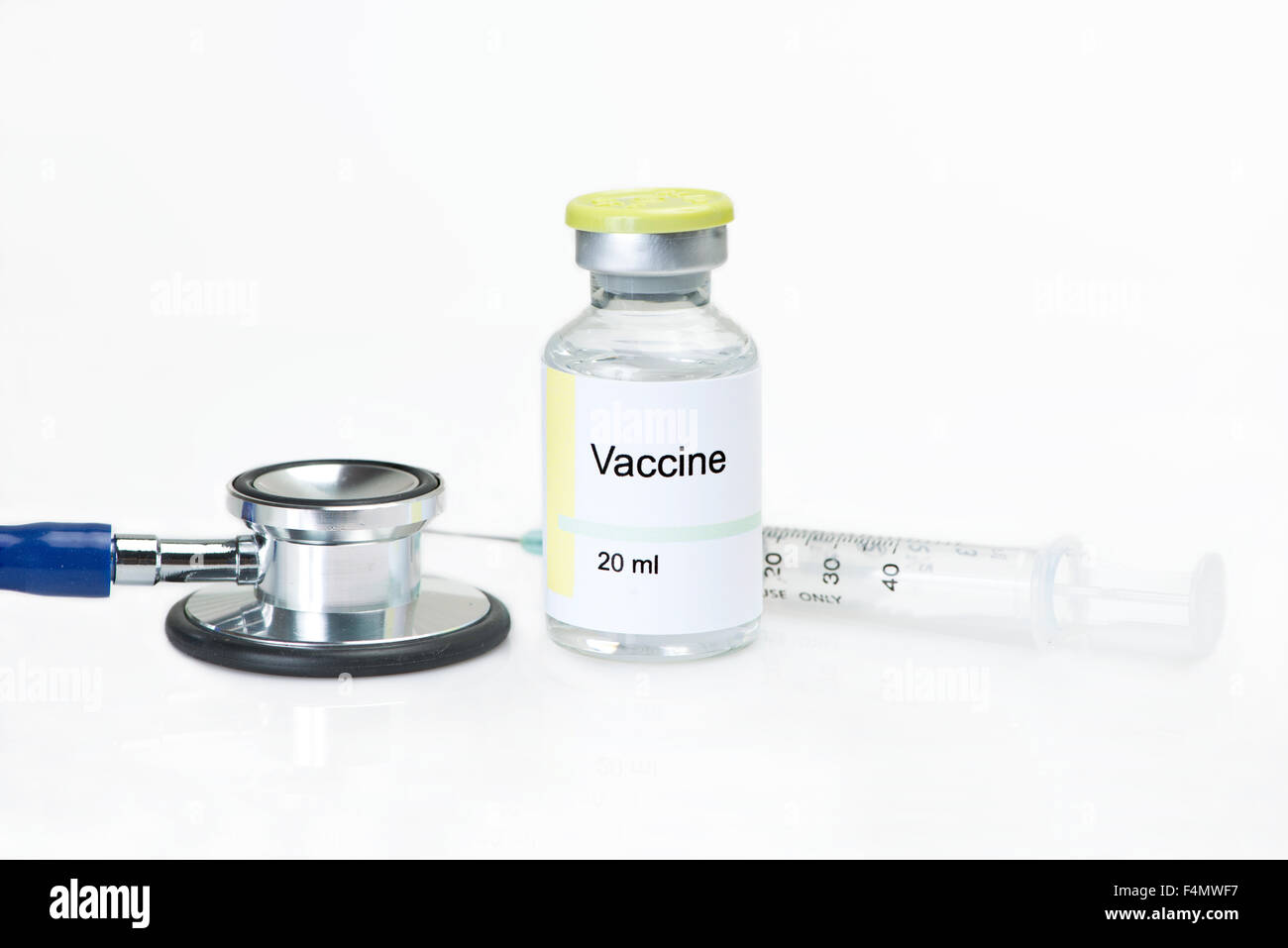 Flaconcino di vaccino con uno stetoscopio e la siringa su sfondo bianco. Etichetta è fittizio, e qualsiasi somiglianza a qualsiasi effettiva del prodotto è Foto Stock