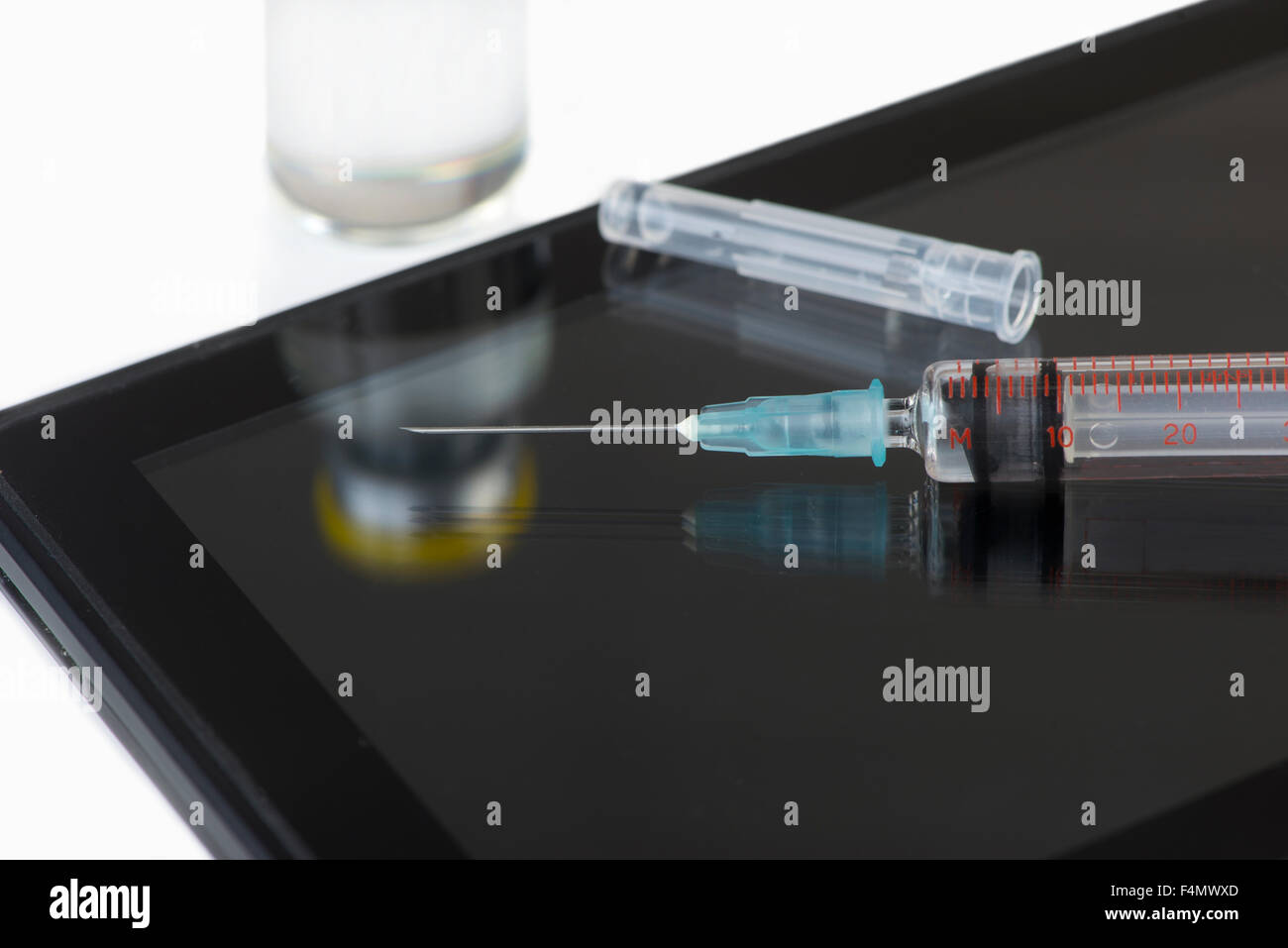 Dispositivo di elaborazione personale con la siringa ed il flaconcino di vaccino. Foto Stock