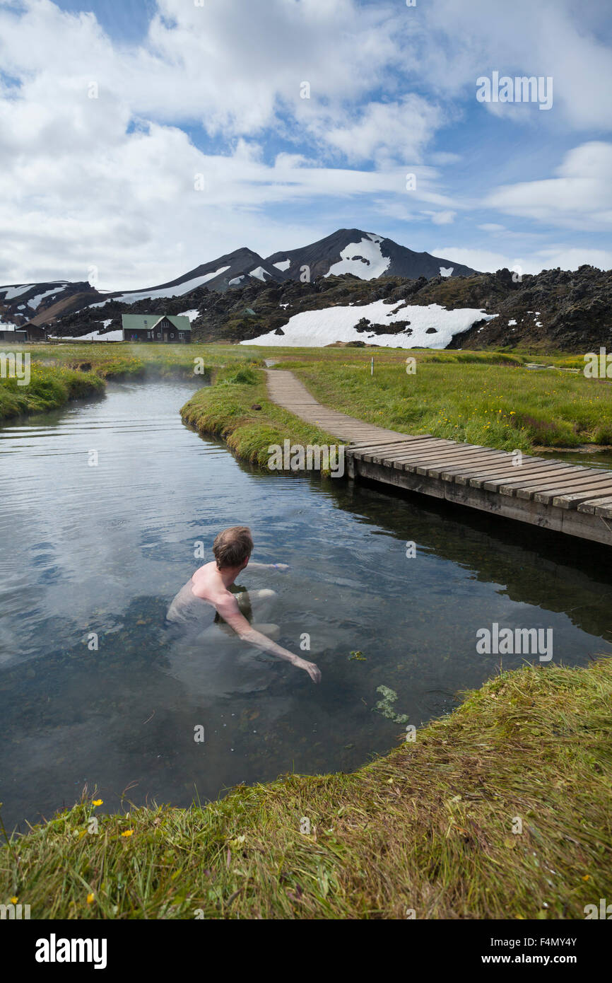 Nuotatore godendo le sorgenti calde di Landmannalaugar, Sudhurland, Islanda. Foto Stock