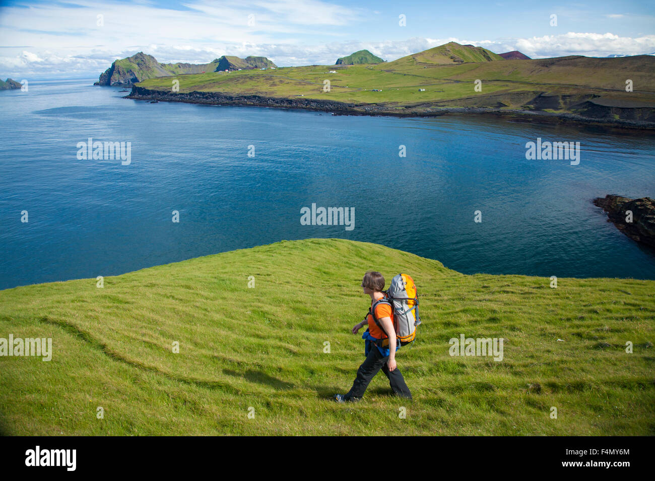 Escursionista esplorare la penisola Storhofdi sull Isola di Heimaey, Isole Westman, Sudhurland, Islanda. Foto Stock