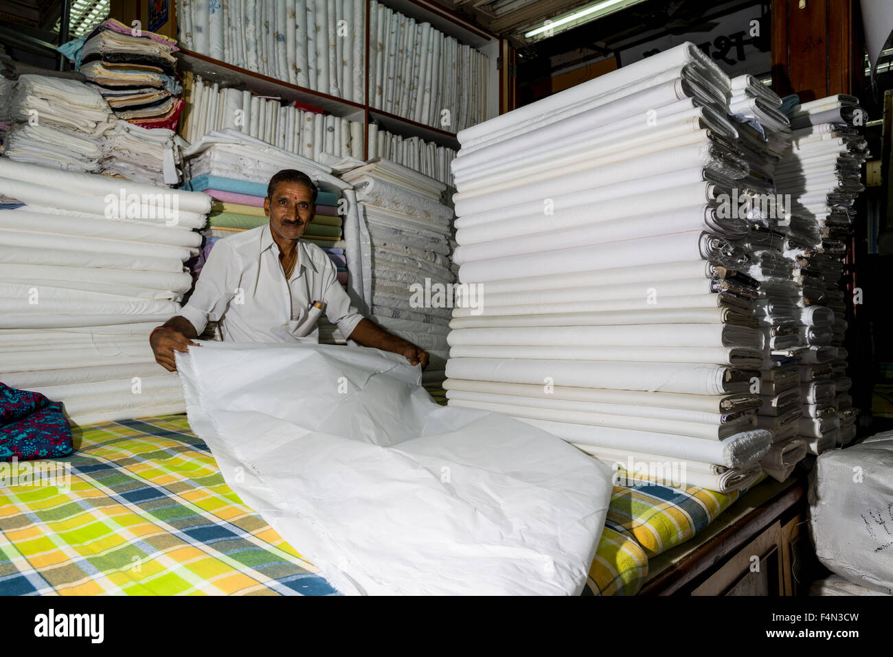 Un venditore sta visualizzando il materiale bianco al mercato mangaldas Foto Stock