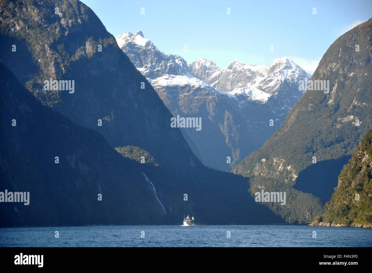 Lancio turistico sopraffatte da montagne a Milford Sound, Fiordland, Nuova Zelanda Foto Stock