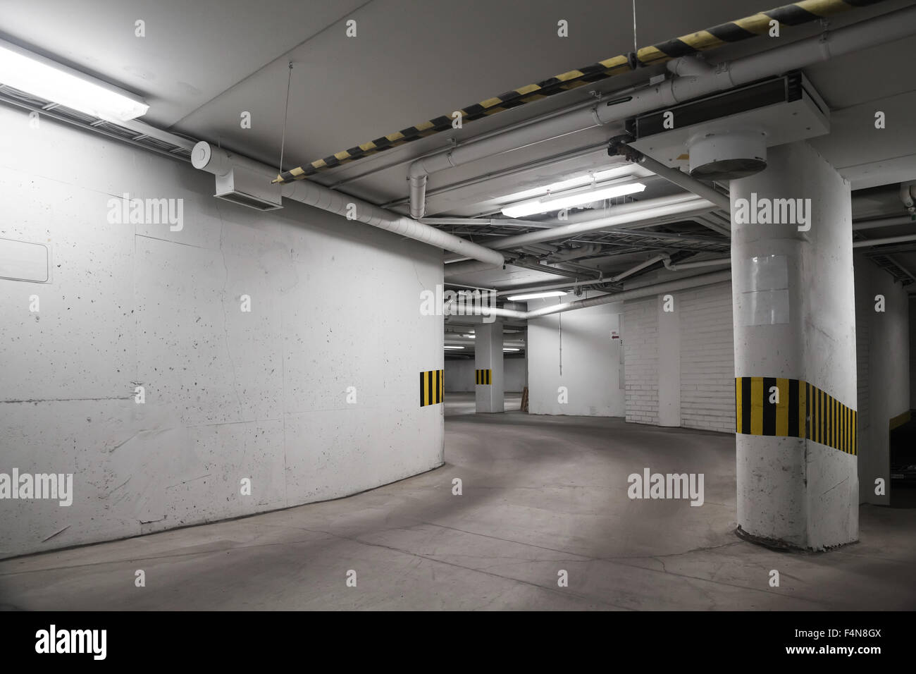 Svuotare il parcheggio sotterraneo interno, pareti di cemento e colonne Foto Stock