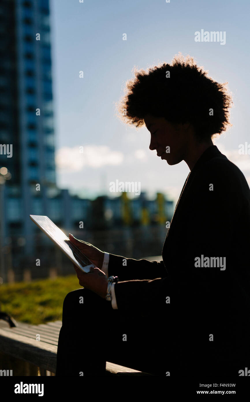 Stati Uniti d'America, New York City, silhouette di imprenditrice guardando a tavoletta digitale Foto Stock