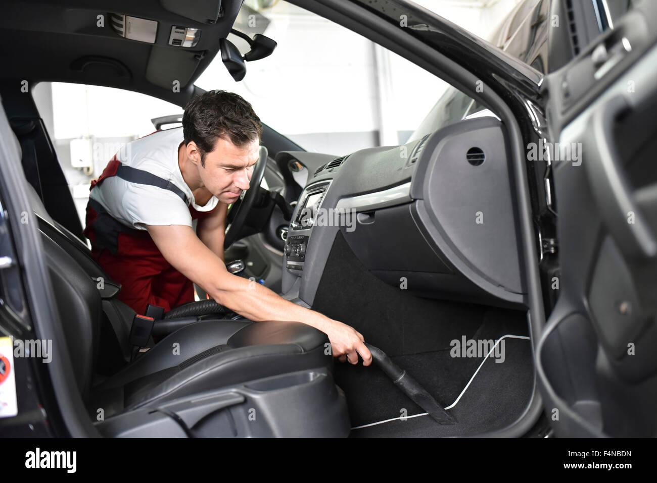 La pulizia dell'auto, uomo hoovering interni per auto Foto Stock