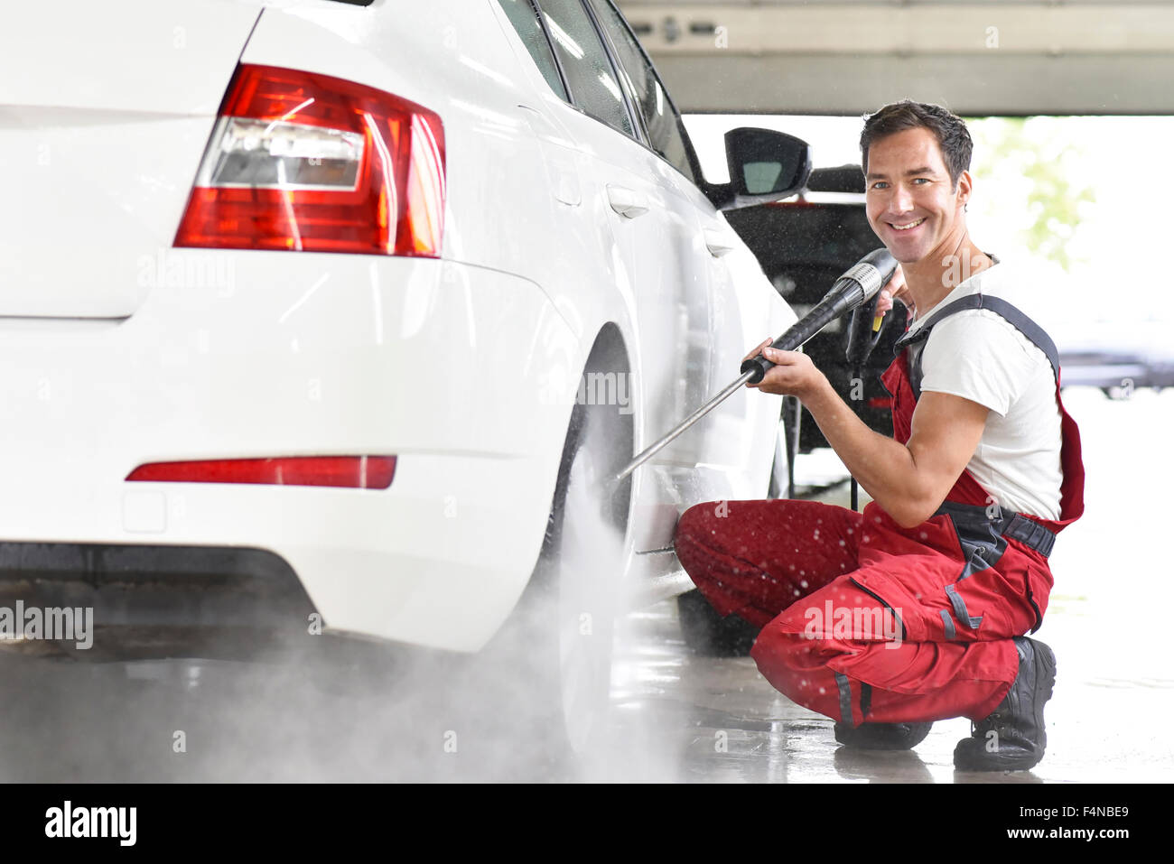 La pulizia dell'auto, uomo auto pulizia con pulitore ad alta pressione Foto Stock