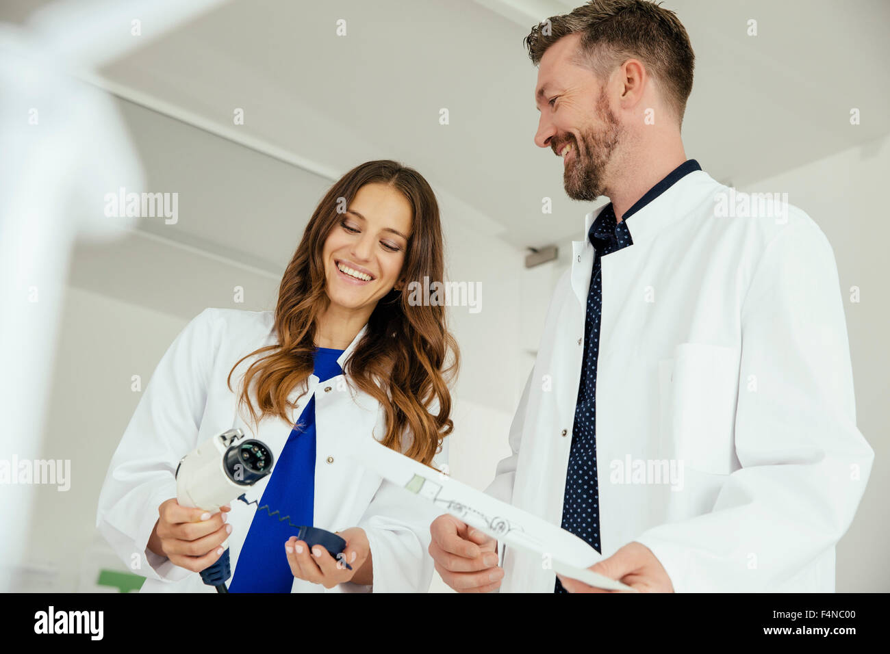 Due scienziati parlando di un auto elettrica plug in laboratorio Foto Stock