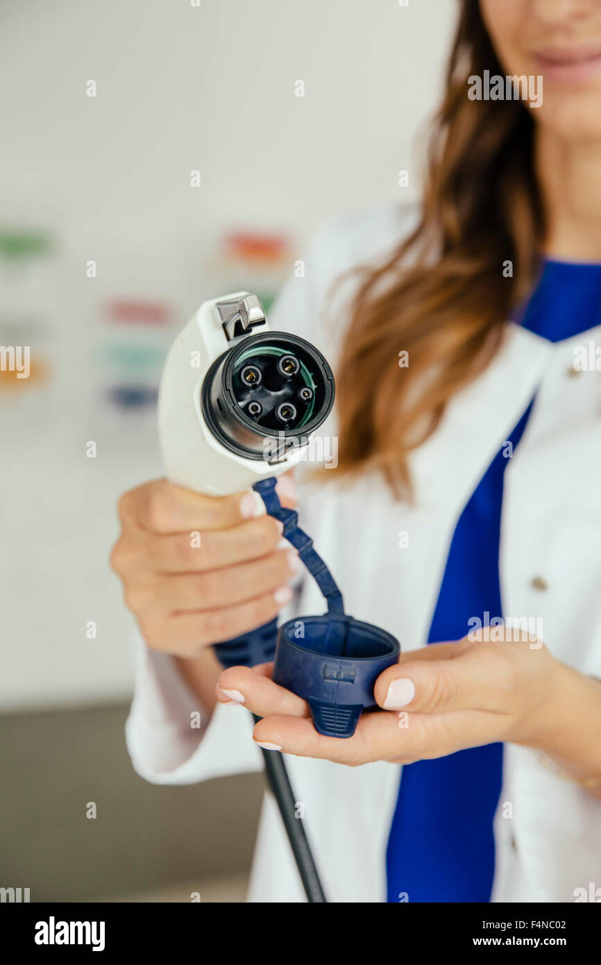 Scienziato di trattenimento di un auto elettrica plug in laboratorio Foto Stock