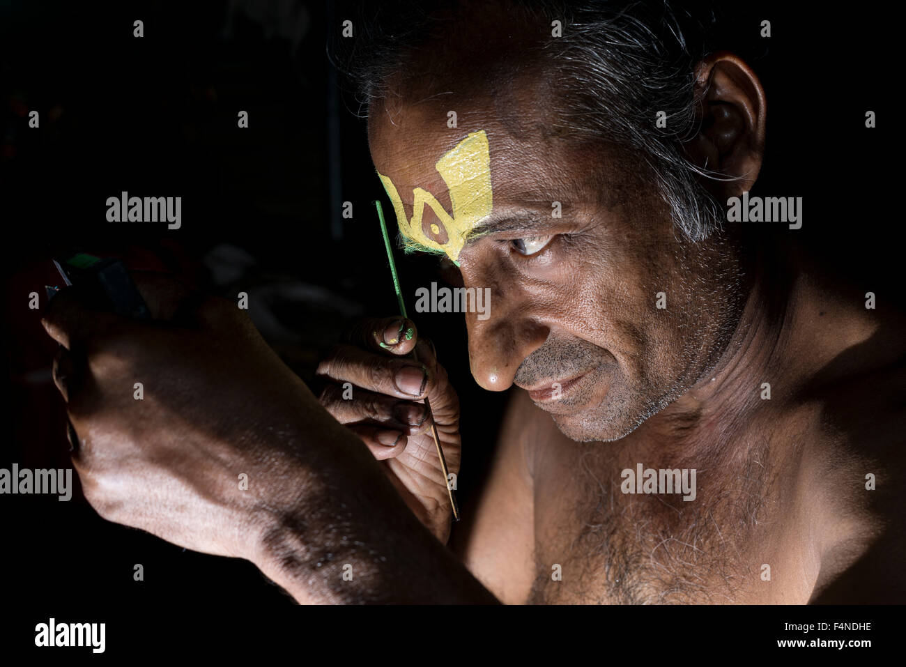 Un artista katakali è applicare il make up del carattere jayantha Foto Stock